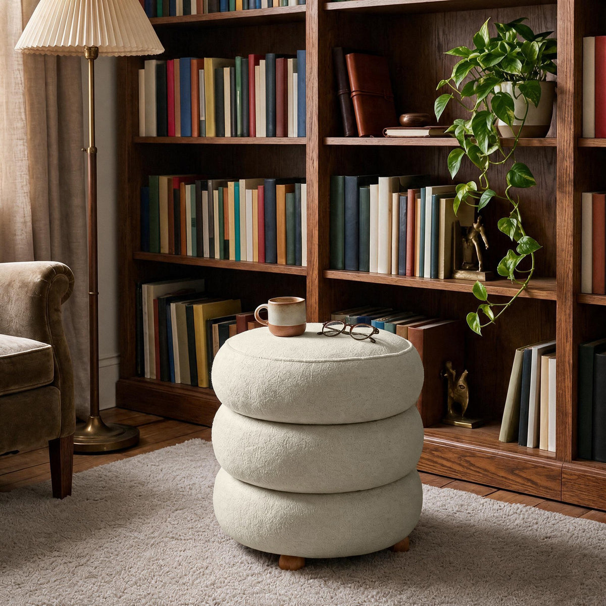 Runder Pouf in Off-White von Hanah Home mit gestricktem Polyesterbezug, Holz-Kugelfüssen und sichtbarem Stauraumfach im Innenraum.