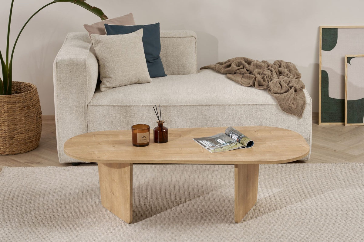 Couchtisch Ovalis von Nordure in Eiche-Optik, Tischplatte aus melaminbeschichteter Spanplatte, Masse 130x65x40 cm, freistehend im Raum.