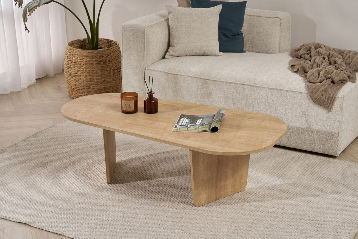 Couchtisch Ovalis von Nordure in Eiche-Optik, Tischplatte aus melaminbeschichteter Spanplatte, Masse 130x65x40 cm, freistehend im Raum.