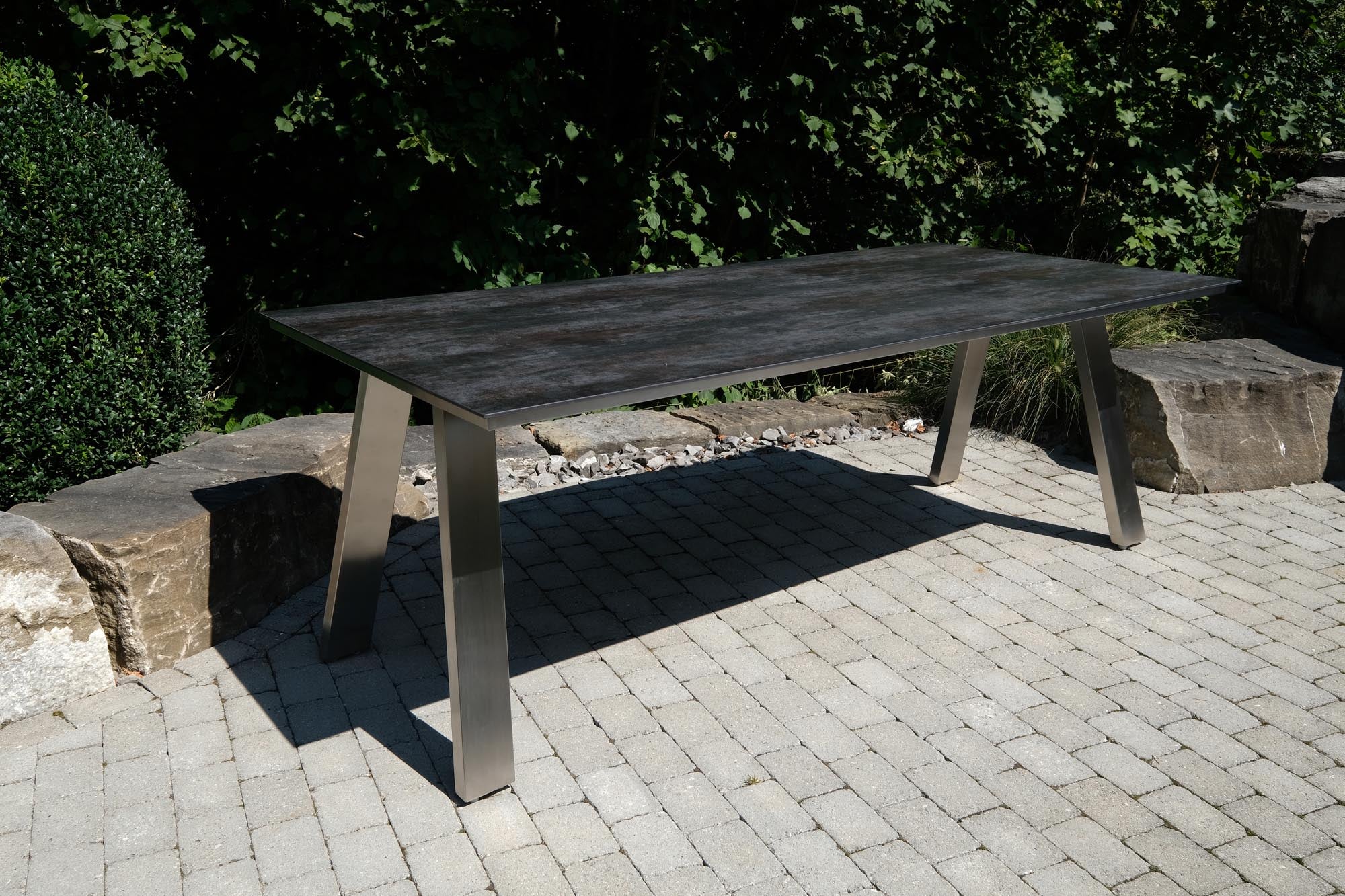 Eleganter Gartentisch Monaco in Edelstahl A-Form, 210x100 cm, ideal für stilvolle Outdoor-Bereiche, präsentiert in modernem Ambiente.