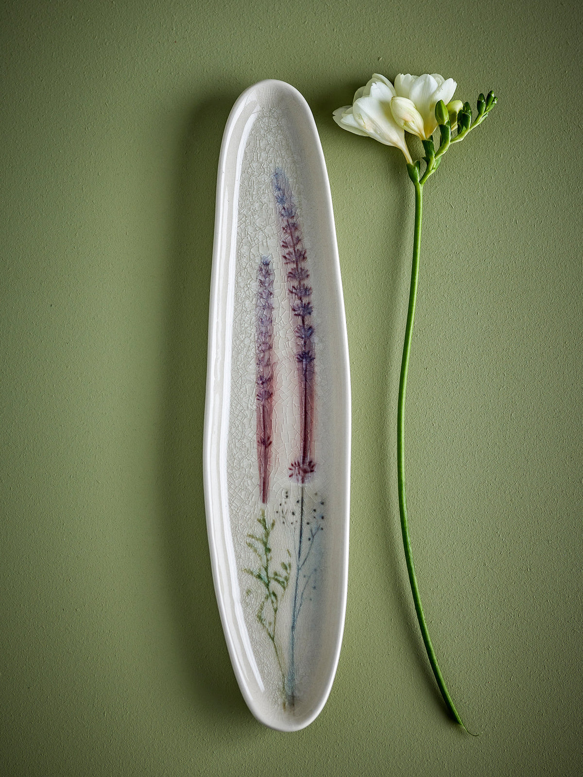 Weisse Servierplatte aus Steingut von Bloomingville mit handgestempeltem Blumenmuster und feiner Krakeleeglasur, länglich geformt.