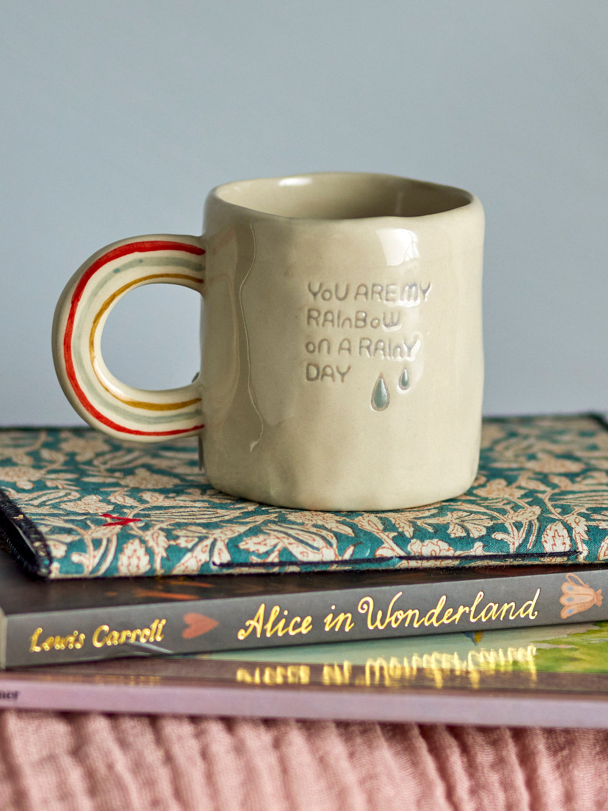 Weisse Cloudy Tasse aus Steingut mit Regenbogen als Griff und Schriftzug