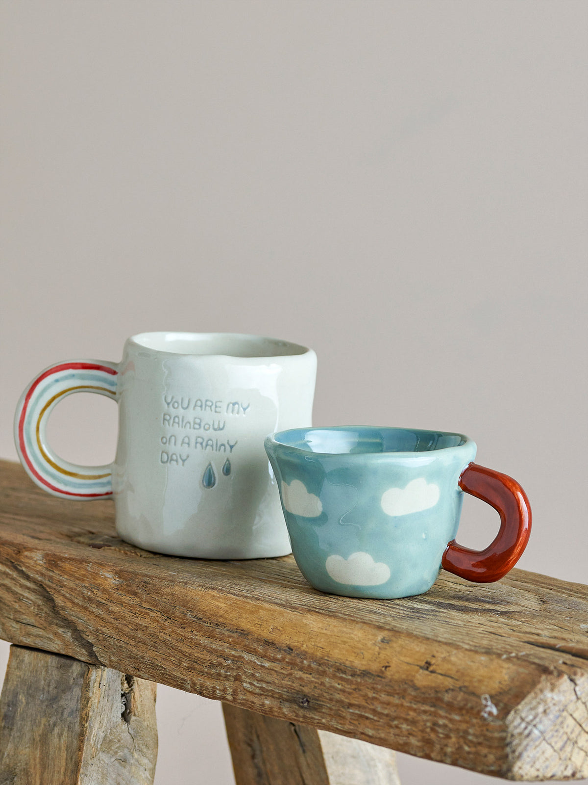 Weisse Tasse aus Steingut mit Regenbogen-Griff und Schriftzug, handbemalt, von Bloomingville Mini, Serie Cloudy, im Boho-Chic-Stil