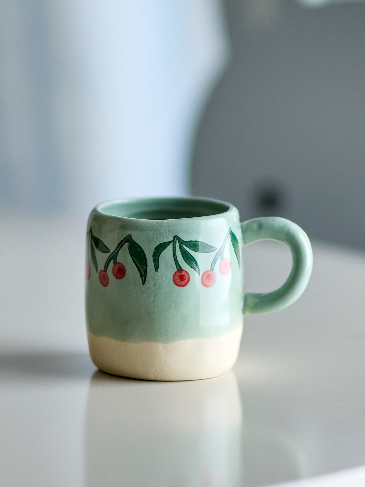 Kleine blaue Tasse aus Steingut von Bloomingville Mini, teilweise handdekoriert mit sichtbaren Farbunterschieden, schlichte runde Form.