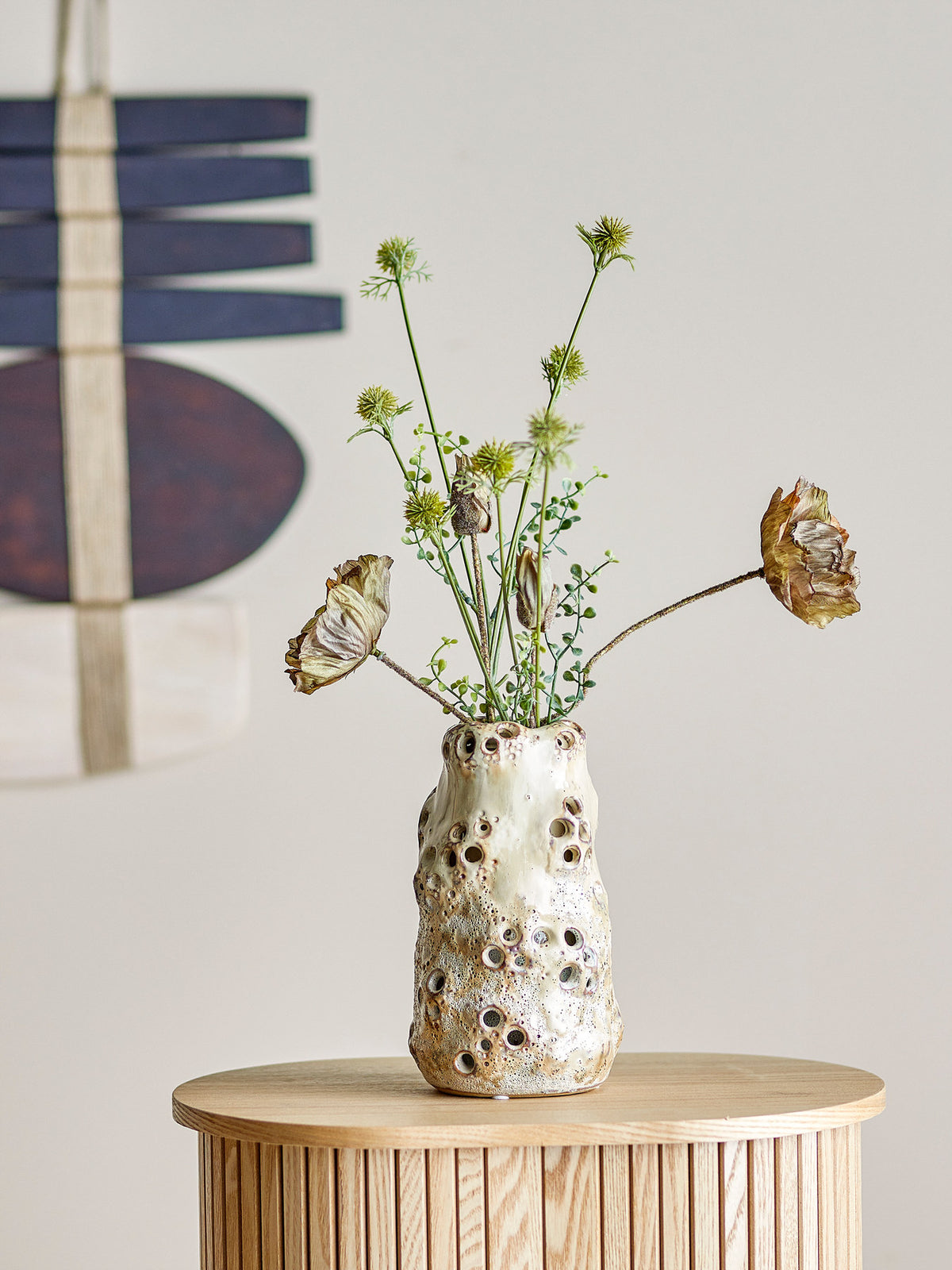 Beige Vase aus Steingut mit zweischichtigem Design: äussere Schicht mit runden Löchern verziert, innerer Behälter für Blumen, Höhe 21.5 cm