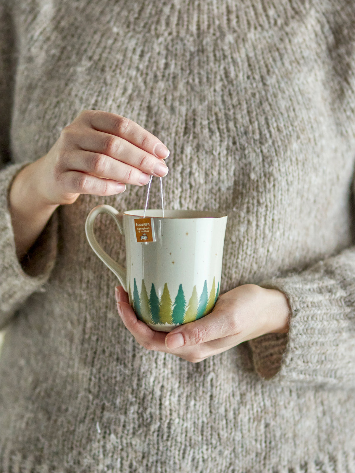 Weisser Steingut-Becher der Serie Spruce von Bloomingville mit Tannenbaum-Motiv und goldenem Rand, klassische runde Form.