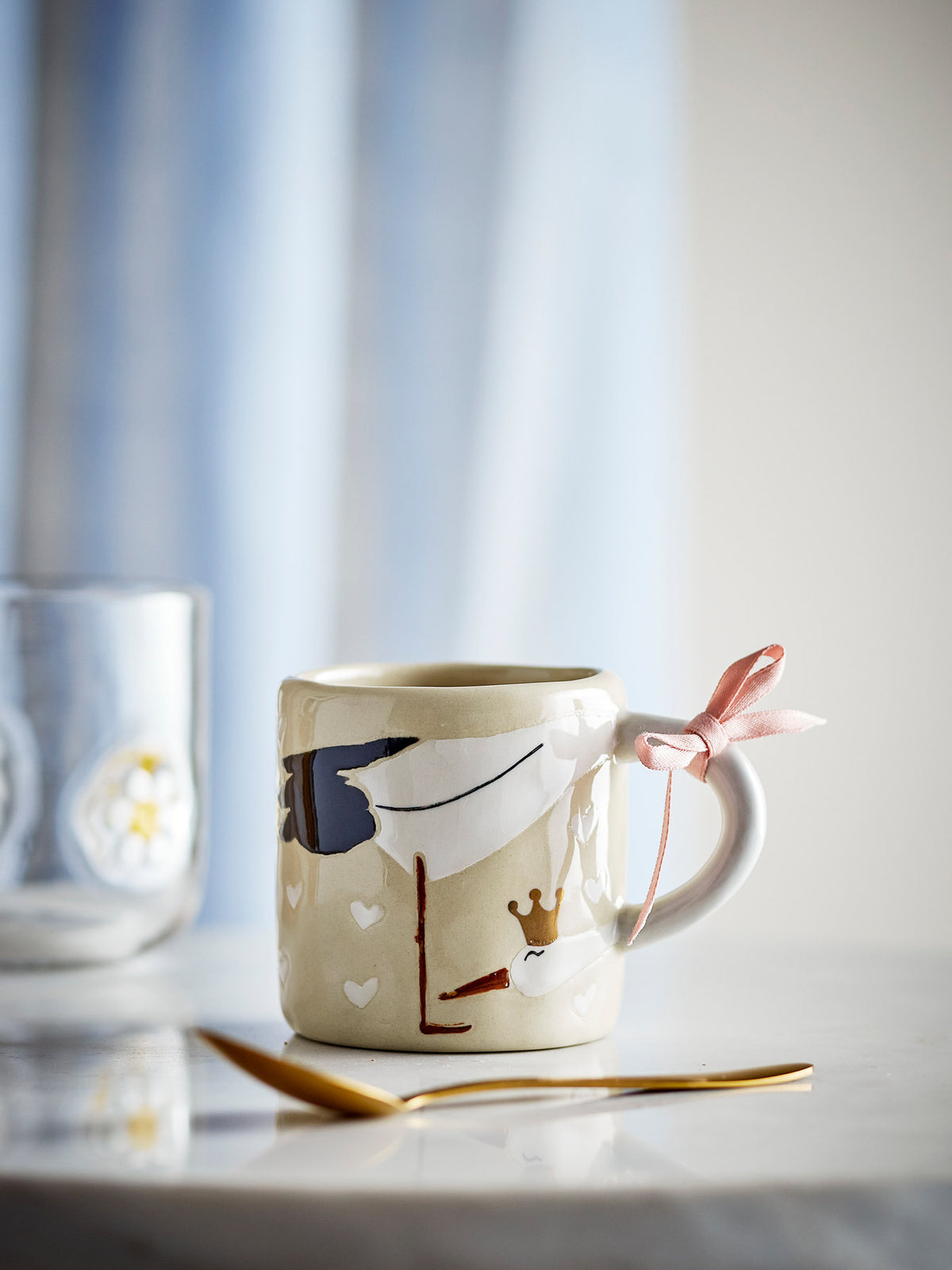 Beige Tasse aus Steingut von Bloomingville Mini, handdekoriert, mit Rose und hellblauem Seidenband um den Henkel gebunden