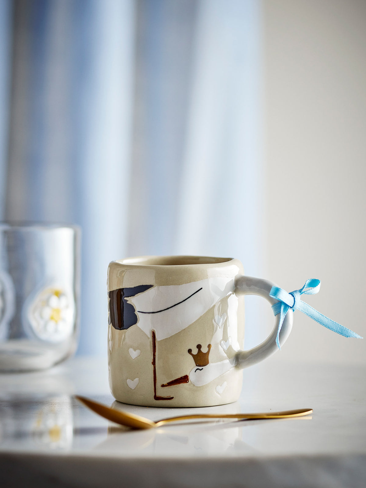 Beige Tasse aus Steingut von Bloomingville Mini, handdekoriert, mit Rose und hellblauem Seidenband um den Henkel gebunden