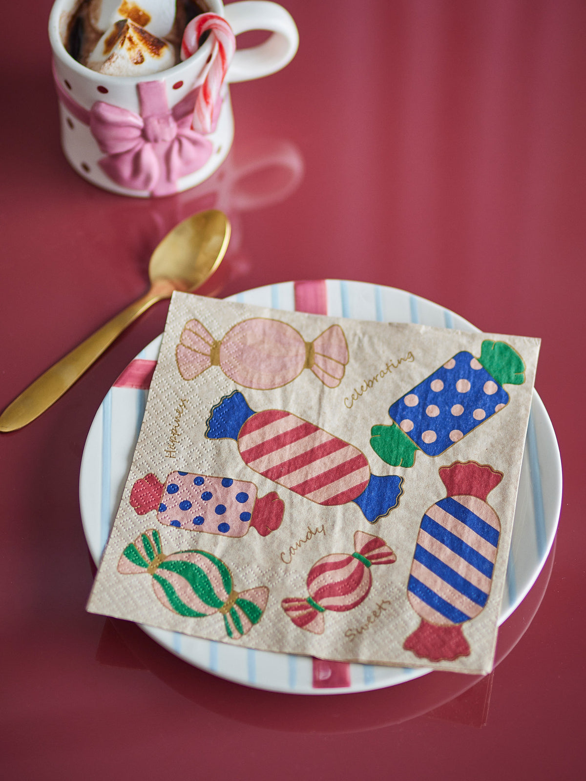 Papierservietten Caramella in Rose mit roten und blauen Bonbonmotiven auf hellbeigem Grund