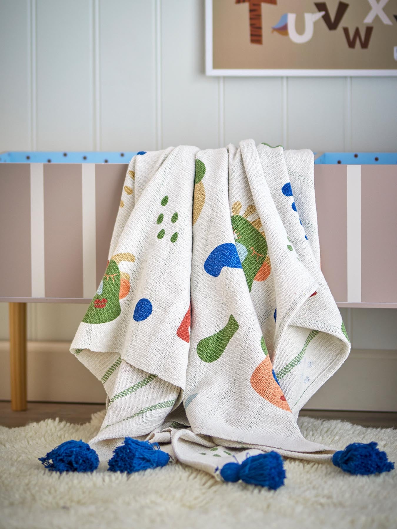 Entdecken Sie die Sylvie Decke von Bloomingville Mini – eine nachhaltige, farbenfrohe Decke aus recycelter Baumwolle, ideal für jedes Kinderzimmer.