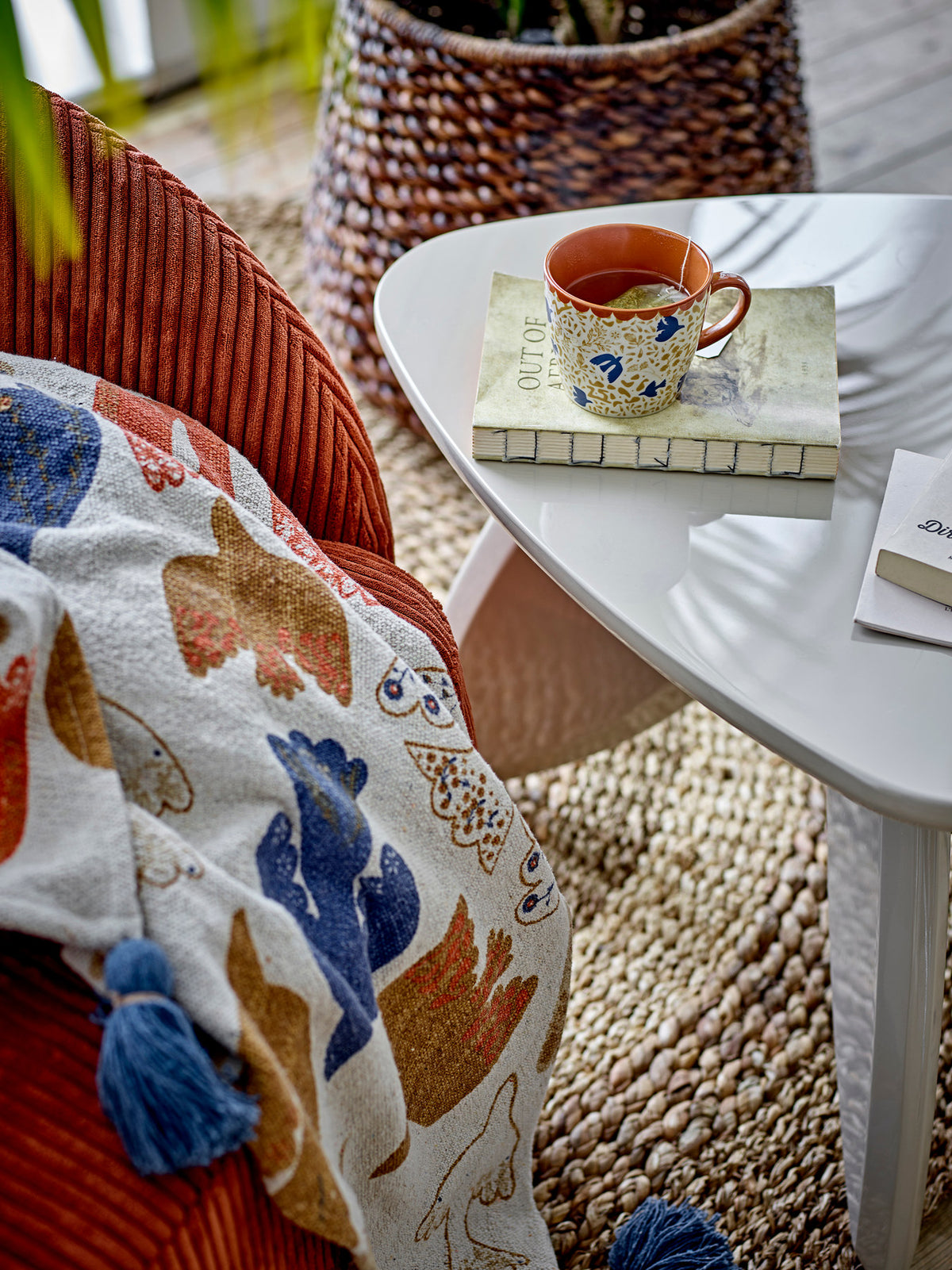 Wolldecke Anniversary von Bloomingville in Braun mit buntem botanischem Druckmuster, aus Baumwolle, Polyester und Viskose, mit blauen Quasten an den Ecken.