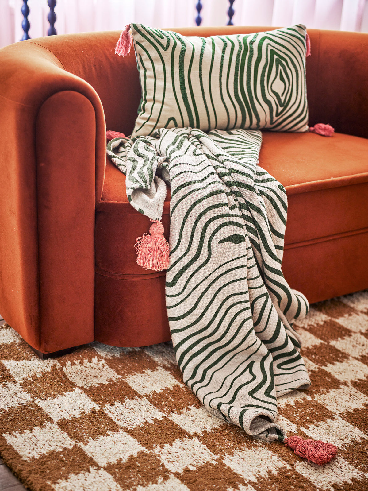 Woodsby Decke von Bloomingville in Beige mit geschwungenen Streifen in Grün und Rosé, Mischfasern, mit grossen Quasten an den Ecken.