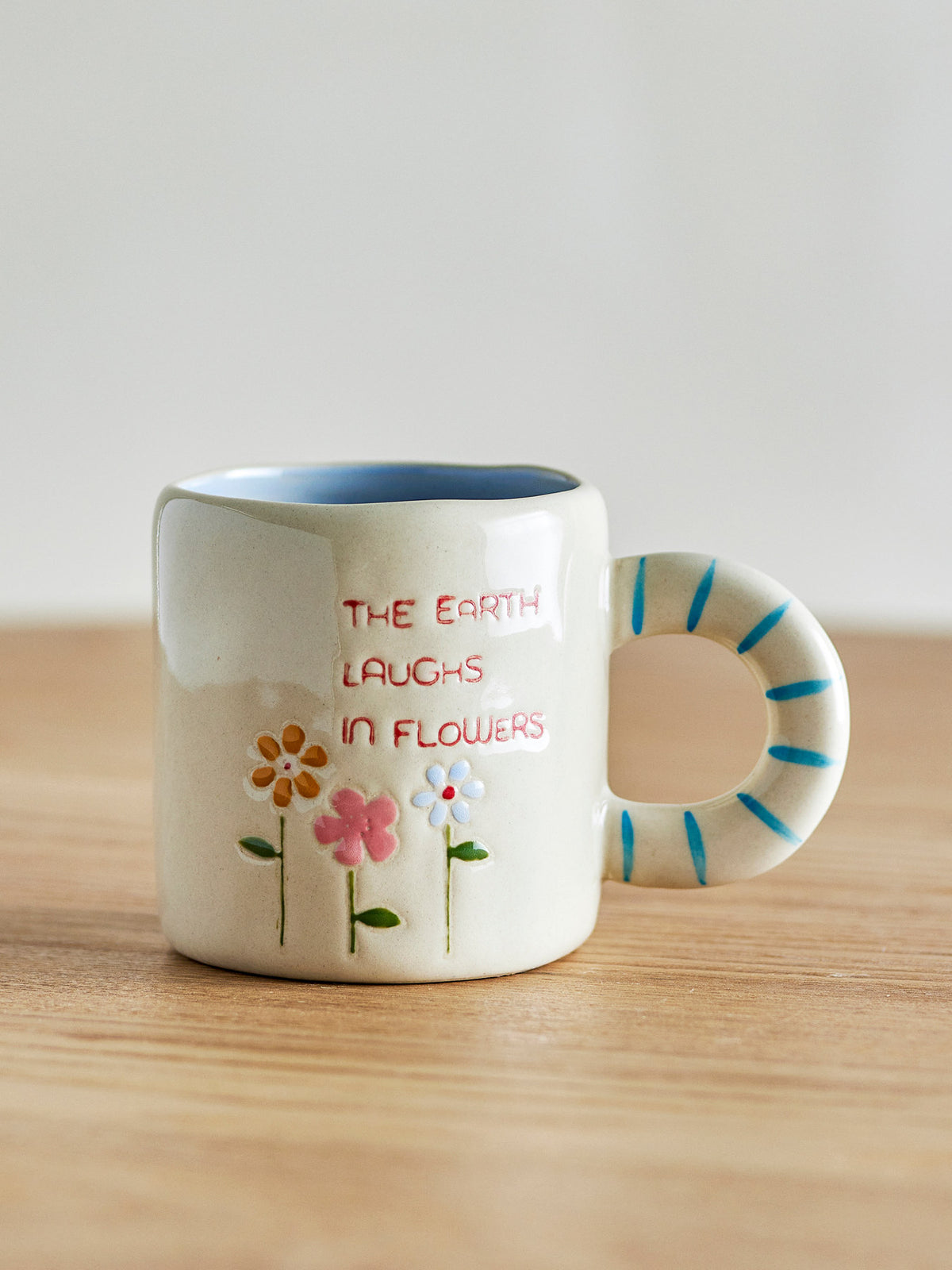 Weisse Cloudy Tasse aus Steingut mit Regenbogen als Griff und Schriftzug