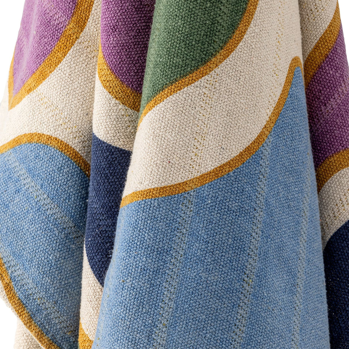 Wolldecke Salacia von Bloomingville in Beige mit geschwungenen Bändern in Blau und Lila, gewebt und bedruckt, mit grauen Quasten an den Ecken.