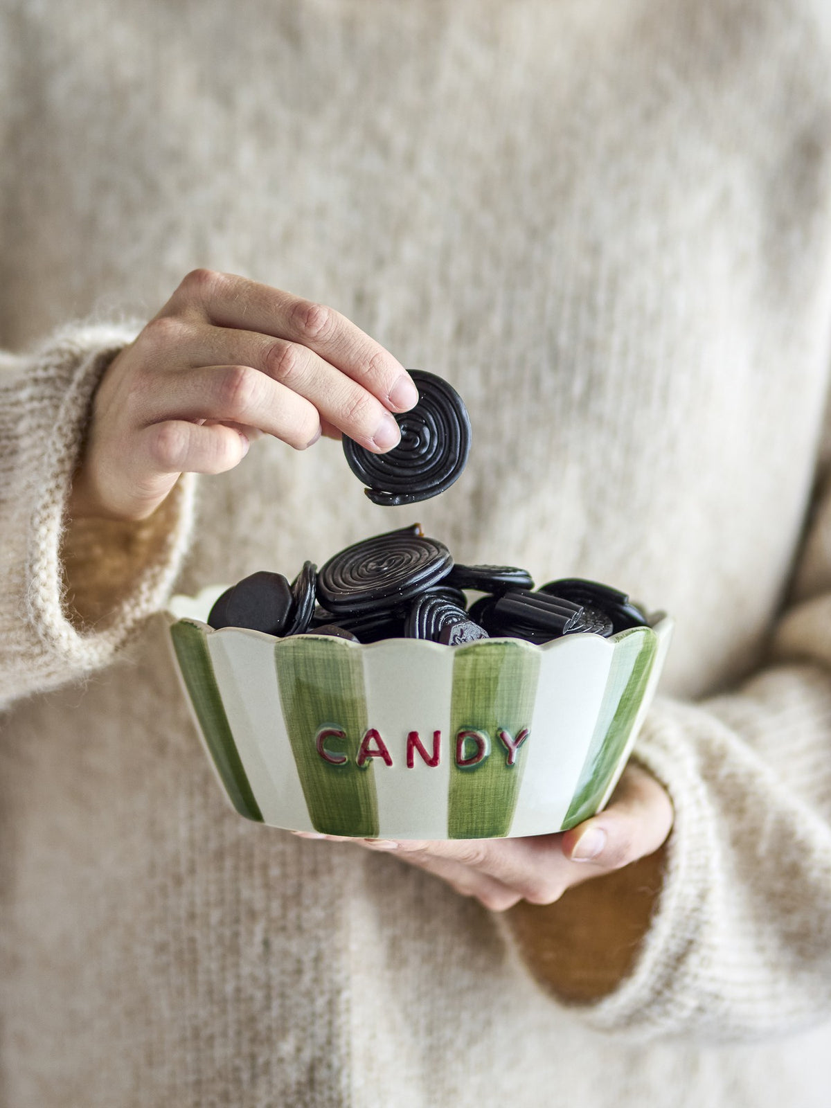 Grüne Servierschale aus Steinzeug mit handgemalten vertikalen Streifen, gewelltem Rand und der Aufschrift „CANDY“, Bloomingville Chip Serie.