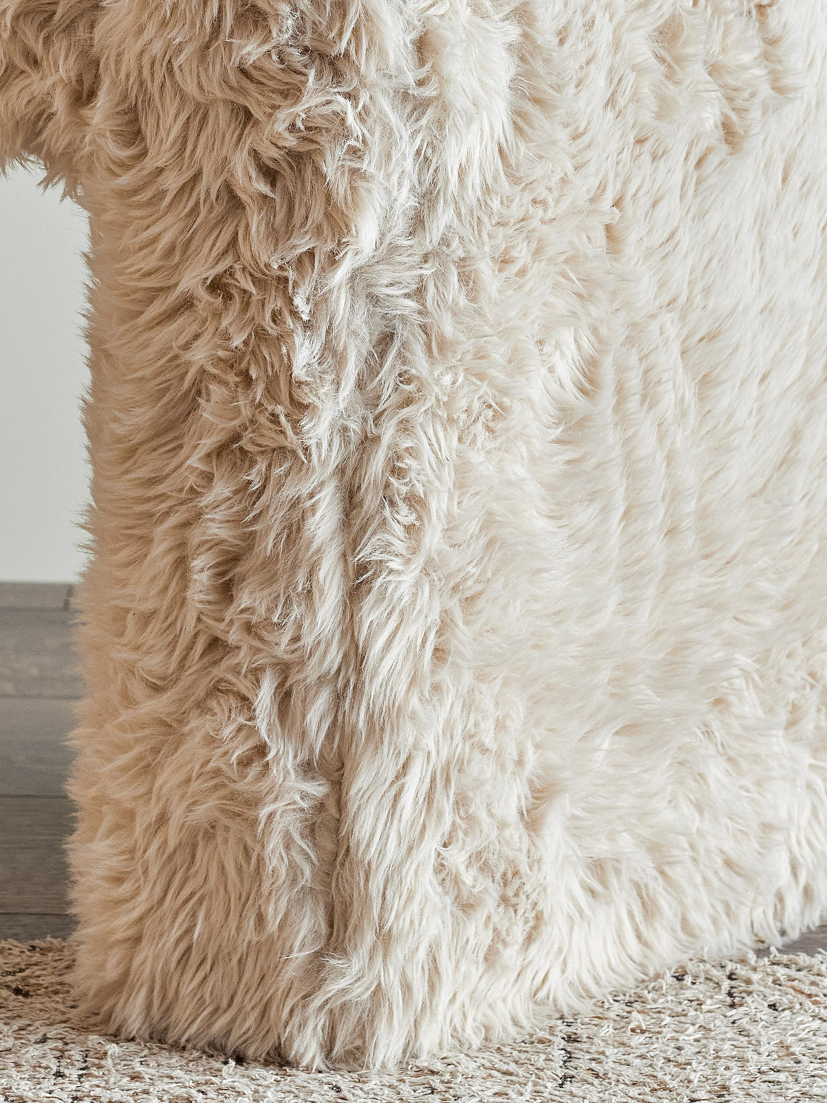Beiger Bobbie Hocker von Bloomingville mit rundlicher Form, Polyesterbezug und Holzbeinen in Naturfarbe, auf hellem Hintergrund fotografiert