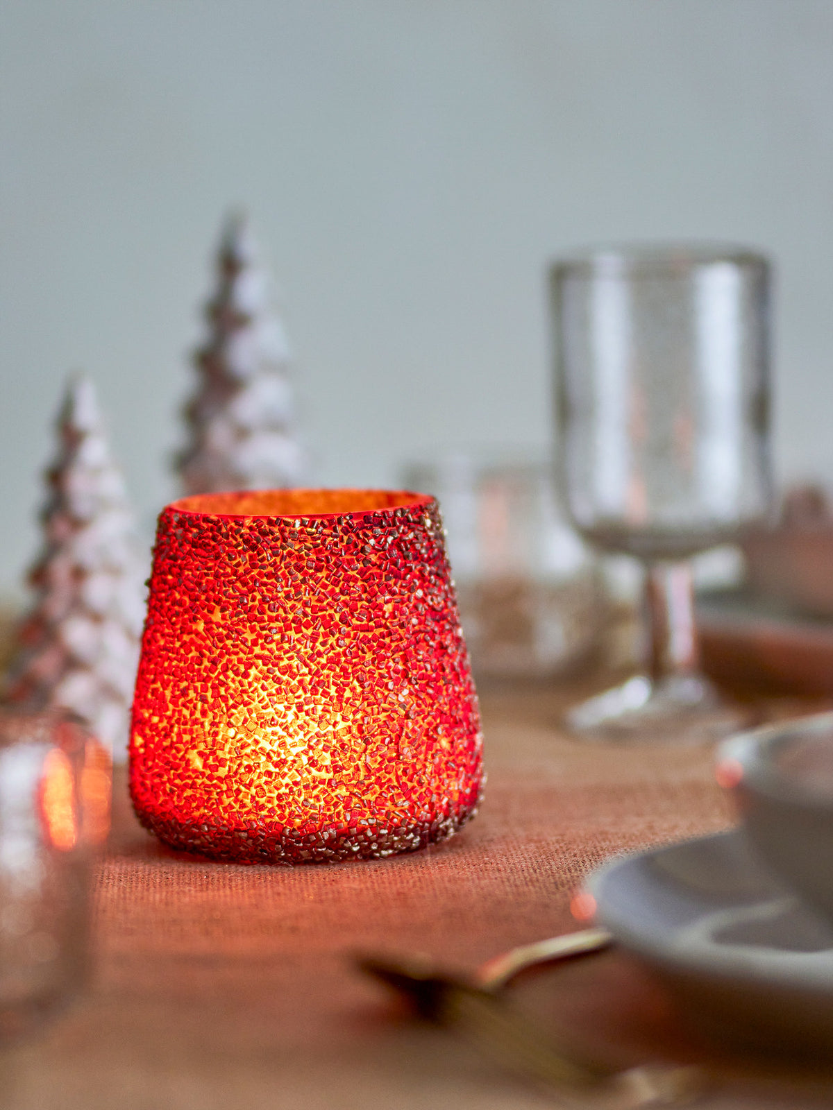 Runder Teelichthalter aus Glas mit goldfarbener Mosaik-Oberfläche und erhabenen Details, Modell Filiz von Bloomingville, Durchmesser und Höhe je 11 cm.