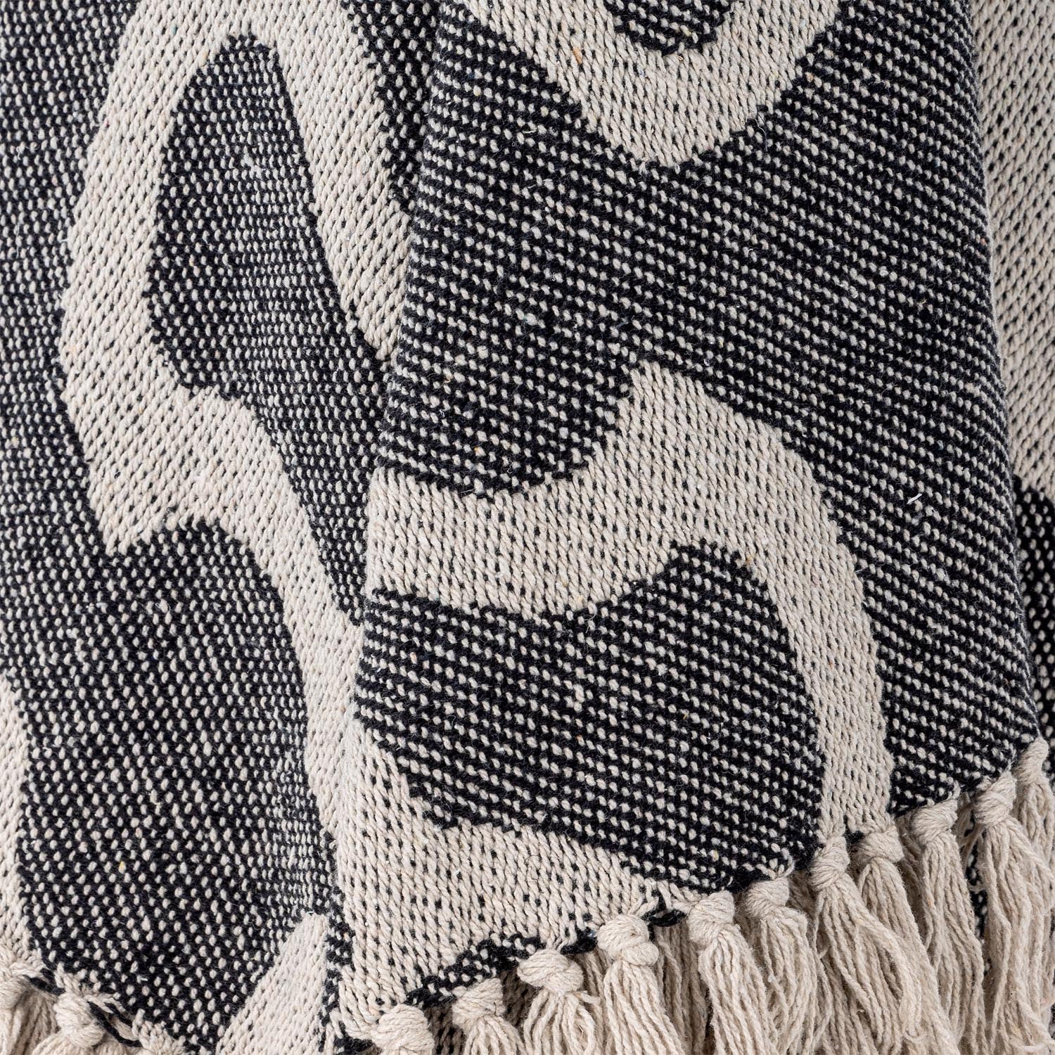 Entdecken Sie die stilvolle Salobre Decke von Bloomingville aus recycelter Baumwolle. Schwarz-beige Design mit Fransen für nachhaltigen Komfort.