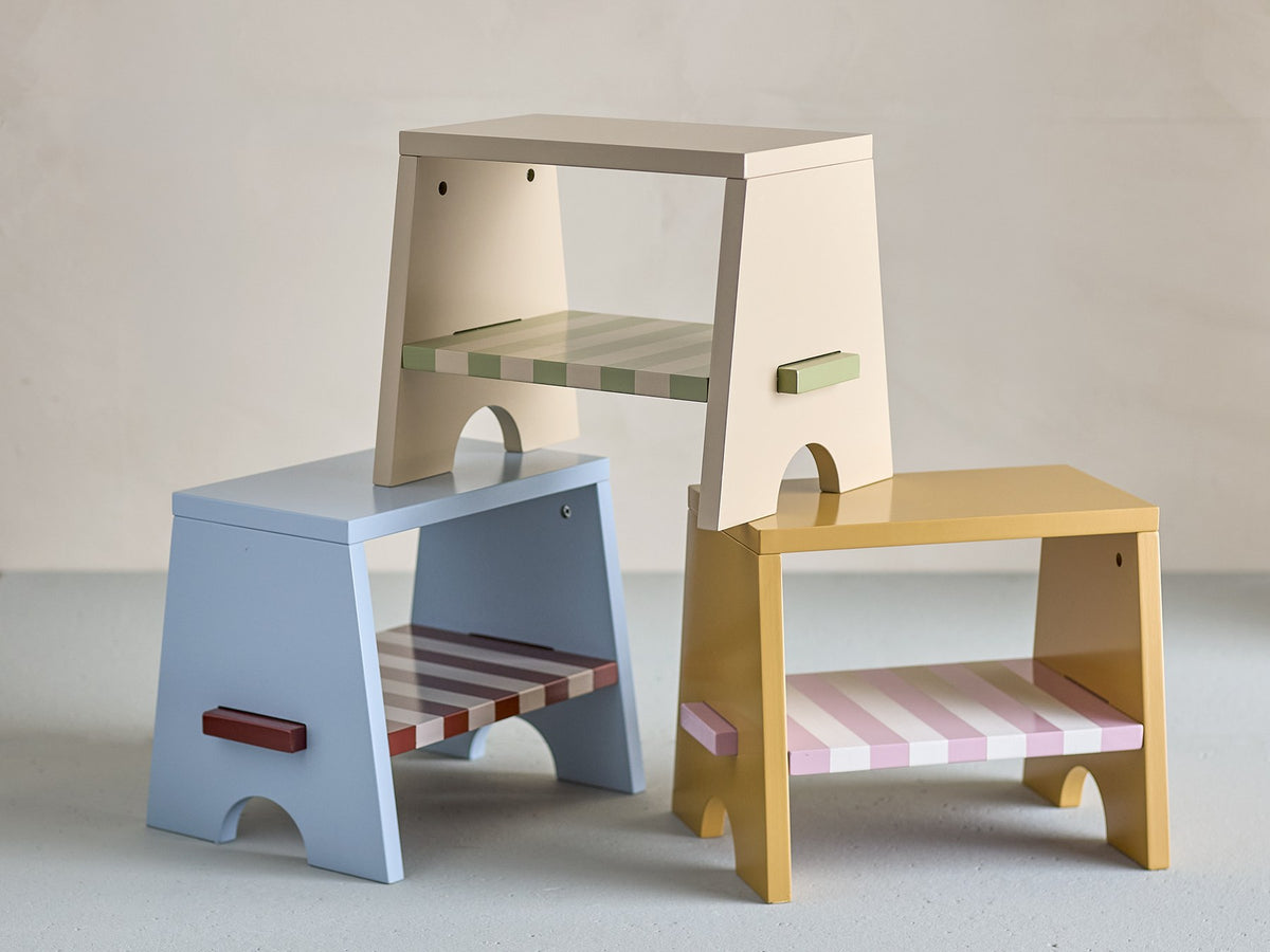 Liova Hocker von Bloomingville Mini aus lackiertem MDF, hellgelber Rahmen mit rosafarbenen Streifen auf der Sitzfläche, kleine Sitzgelegenheit.