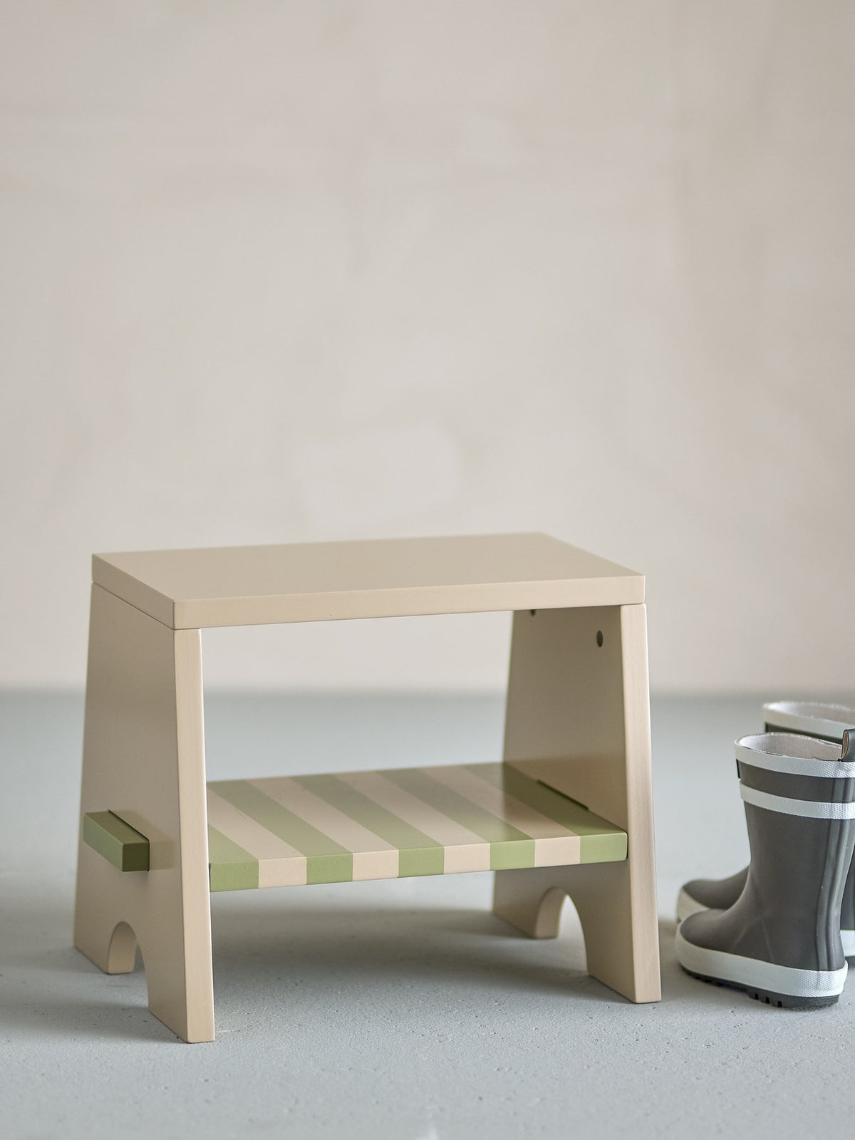 Liova Hocker von Bloomingville Mini aus lackiertem MDF, hellgelber Rahmen mit rosafarbenen Streifen auf der Sitzfläche, kleine Sitzgelegenheit.