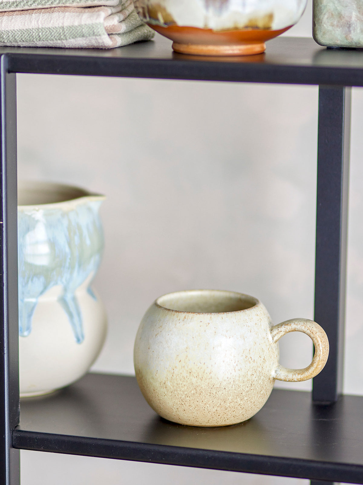 Beige Tasse aus Steingut mit Henkel, Modell Paula von Bloomingville, reaktive Glasur mit warmen Sandtönen, Fassungsvermögen 410 ml.