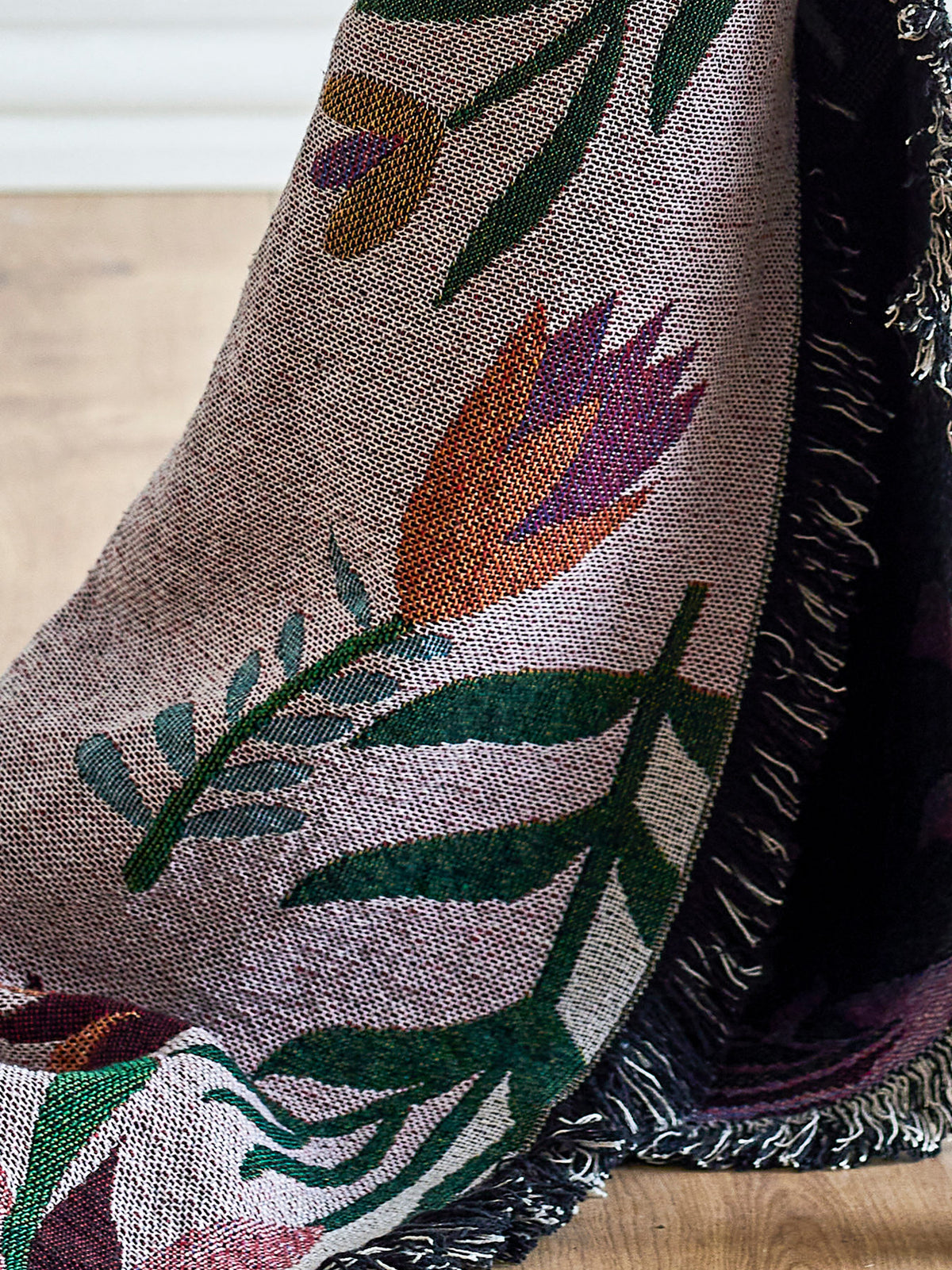 Gewebte Wolldecke Yash in Multi mit botanischem Muster auf beiden Seiten, Mischfasern aus Baumwolle, Polyester, Viskose und Wolle, mit bunten Fransen am Rand.