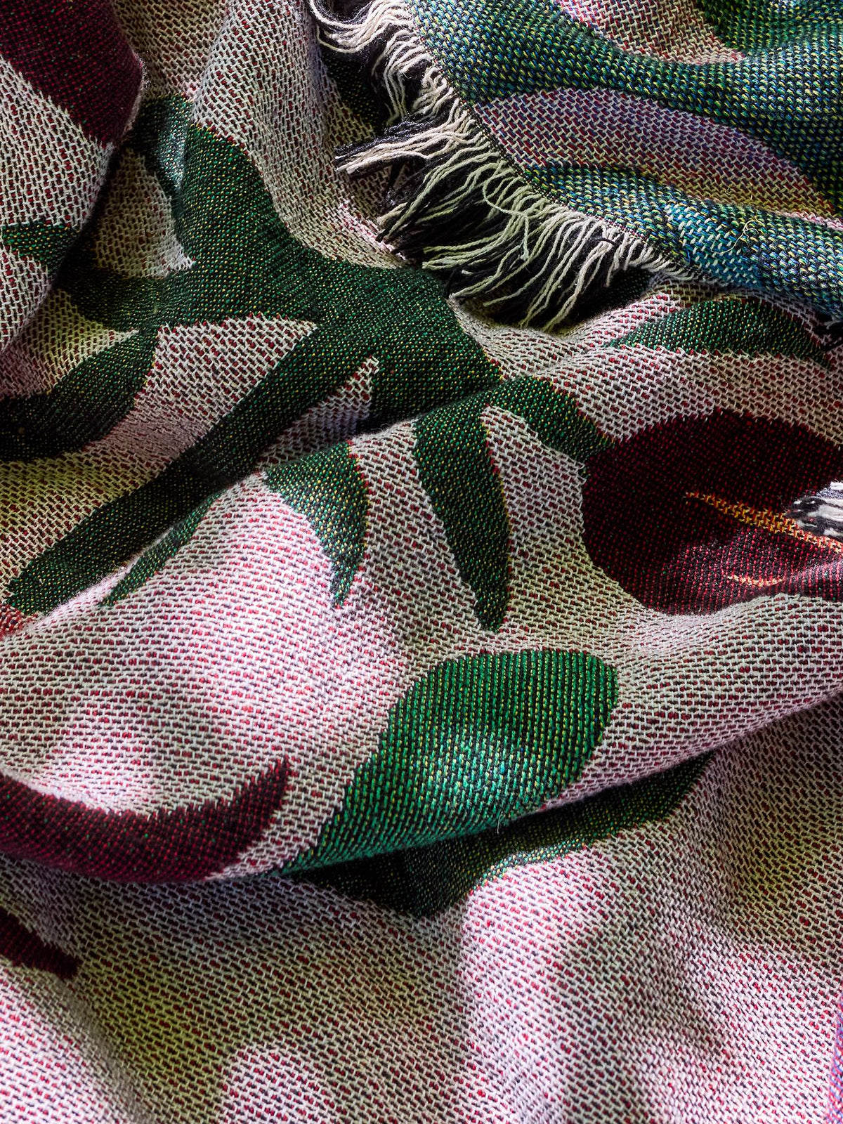 Gewebte Wolldecke Yash in Multi mit botanischem Muster auf beiden Seiten, Mischfasern aus Baumwolle, Polyester, Viskose und Wolle, mit bunten Fransen am Rand.