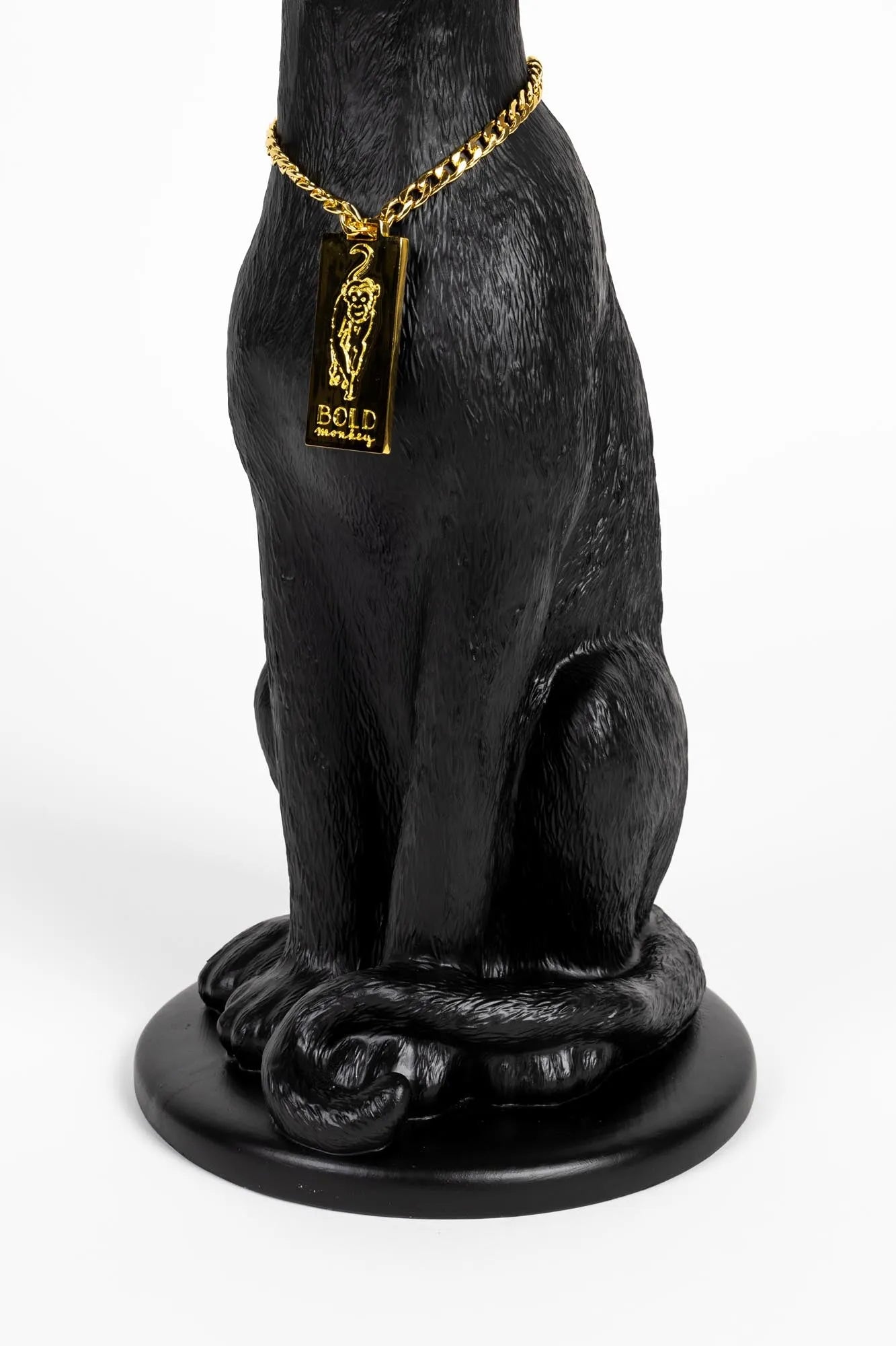 Ein majestätischer Panther-Kerzenleuchter in Schwarz und Gold, verziert mit einer goldenen Kette, strahlt Eleganz und Stil aus.