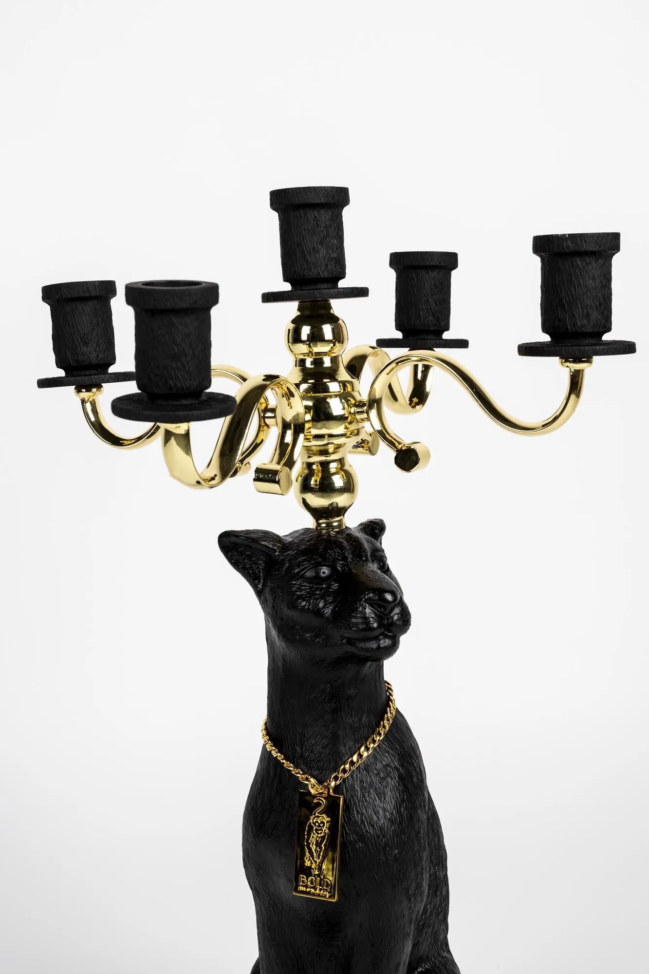 Ein majestätischer Panther-Kerzenleuchter in Schwarz und Gold, verziert mit einer goldenen Kette, strahlt Eleganz und Stil aus.