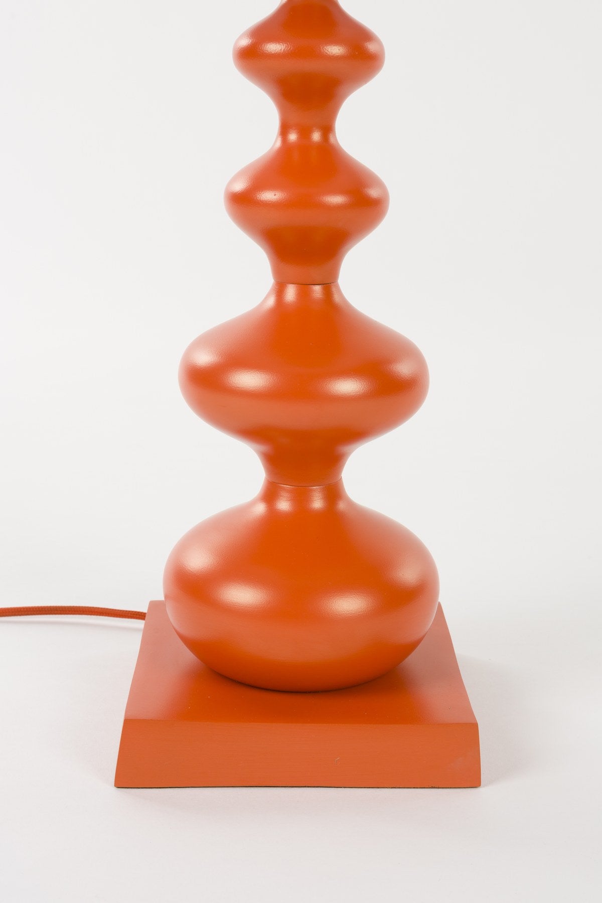 Stehlampe von Bold Monkey aus Eisen in leuchtendem Orange, geschwungene Form, mit E27-Fassung, Höhe 78 cm, für den Innenbereich.