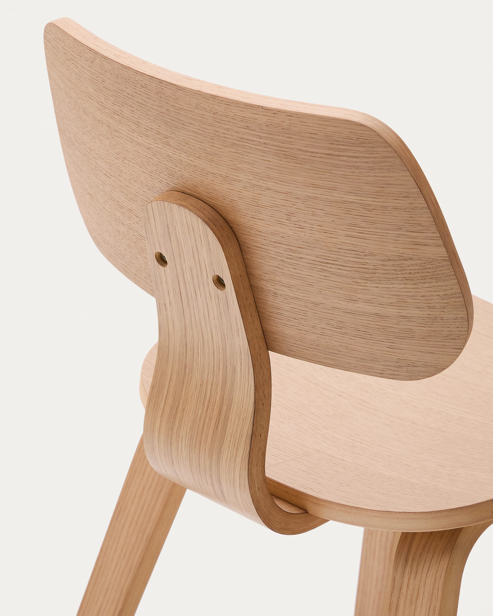 Der Stuhl Gena von Kave Home vereint Eichenfurnier und Kautschukholz, bietet Komfort und Eleganz für ein modernes Wohnambiente.