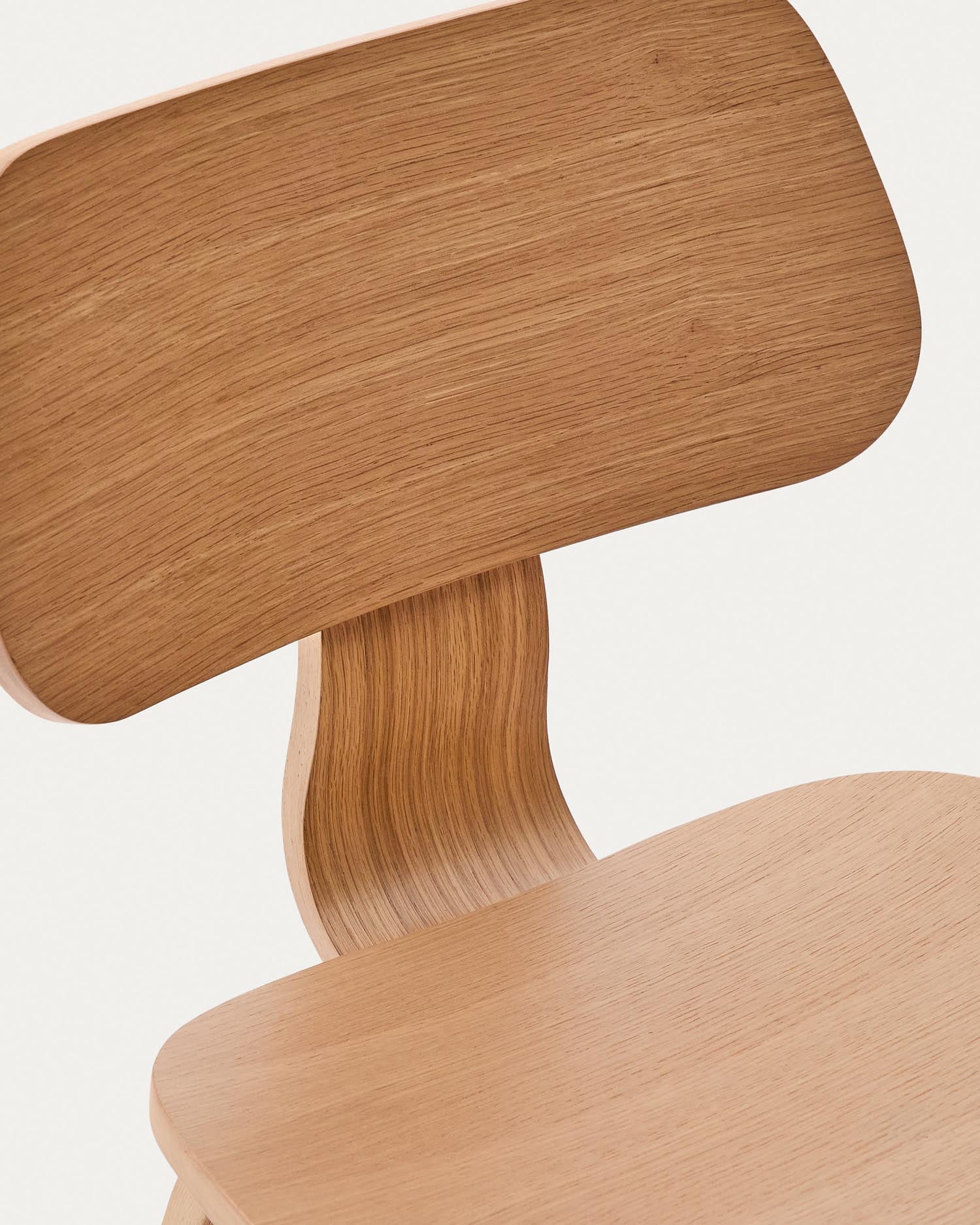 Der Stuhl Gena von Kave Home kombiniert Eichenfurnier und Kautschukholz, ideal für stilvolle und komfortable Wohnräume.