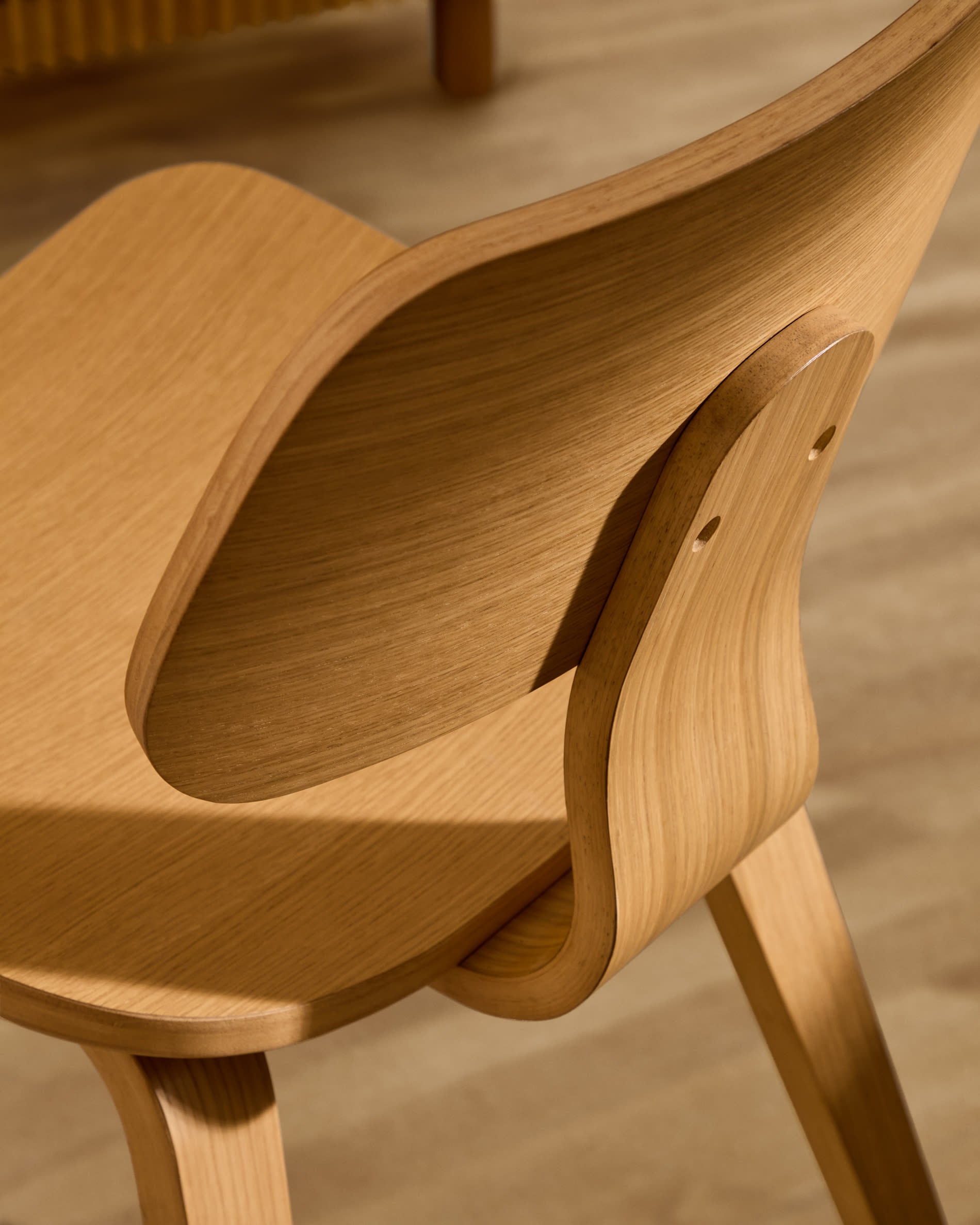 Der Stuhl Gena von Kave Home kombiniert Eichenfurnier und Kautschukholz für ein stilvolles und langlebiges Design.