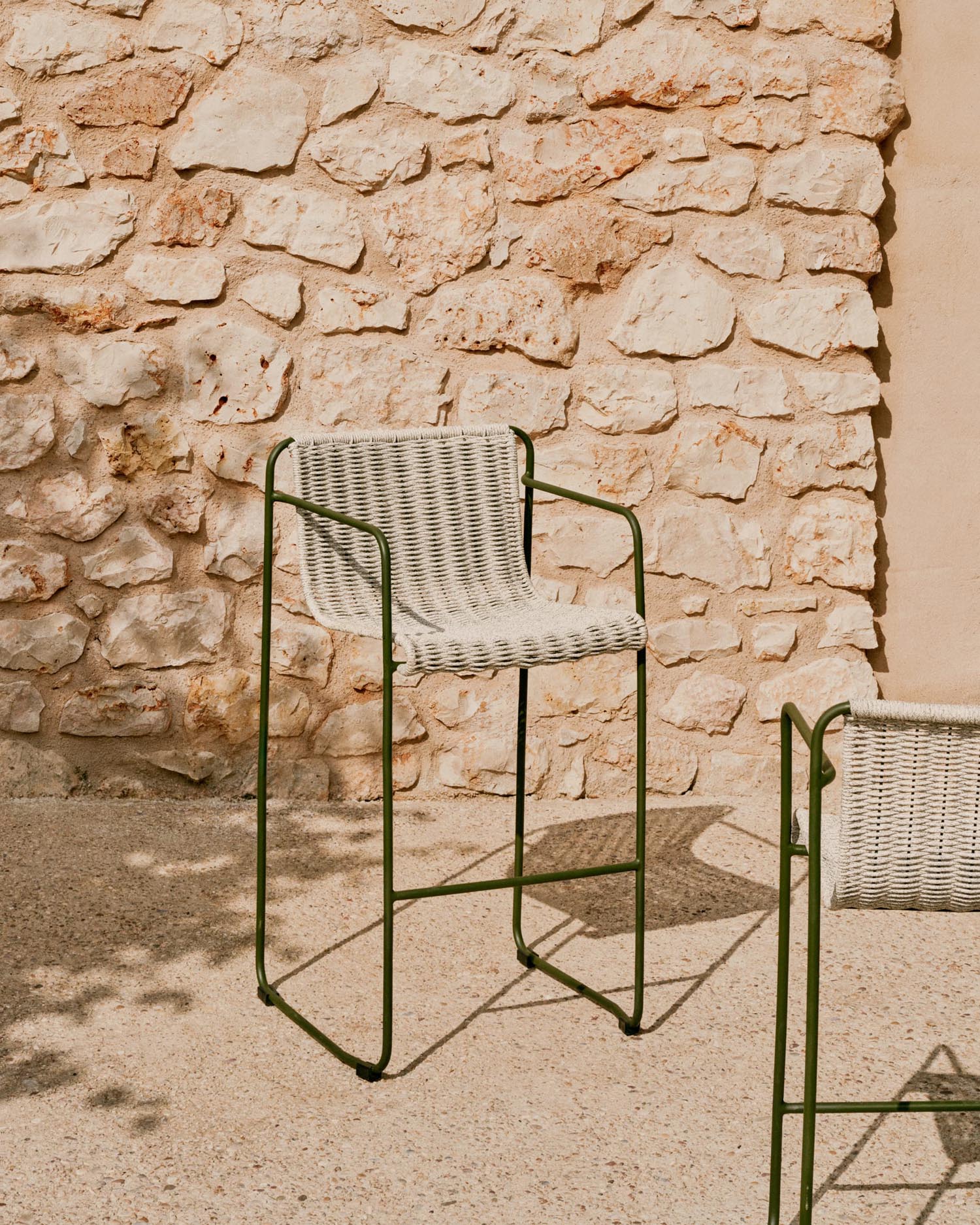 Der Hocker Maurina vereint modernes Design mit Funktionalität: grüner Stahlrahmen, écru-graues Seil, ideal für stilvolle Aussenbereiche.