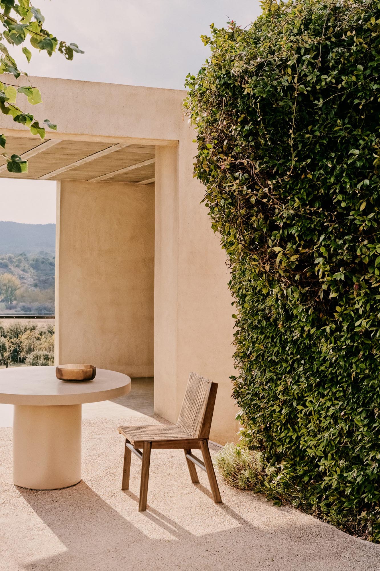 Eleganter Stuhl aus Teakholz und Rattan, nachhaltig und wetterfest, ideal für stilvolle Outdoor-Bereiche.