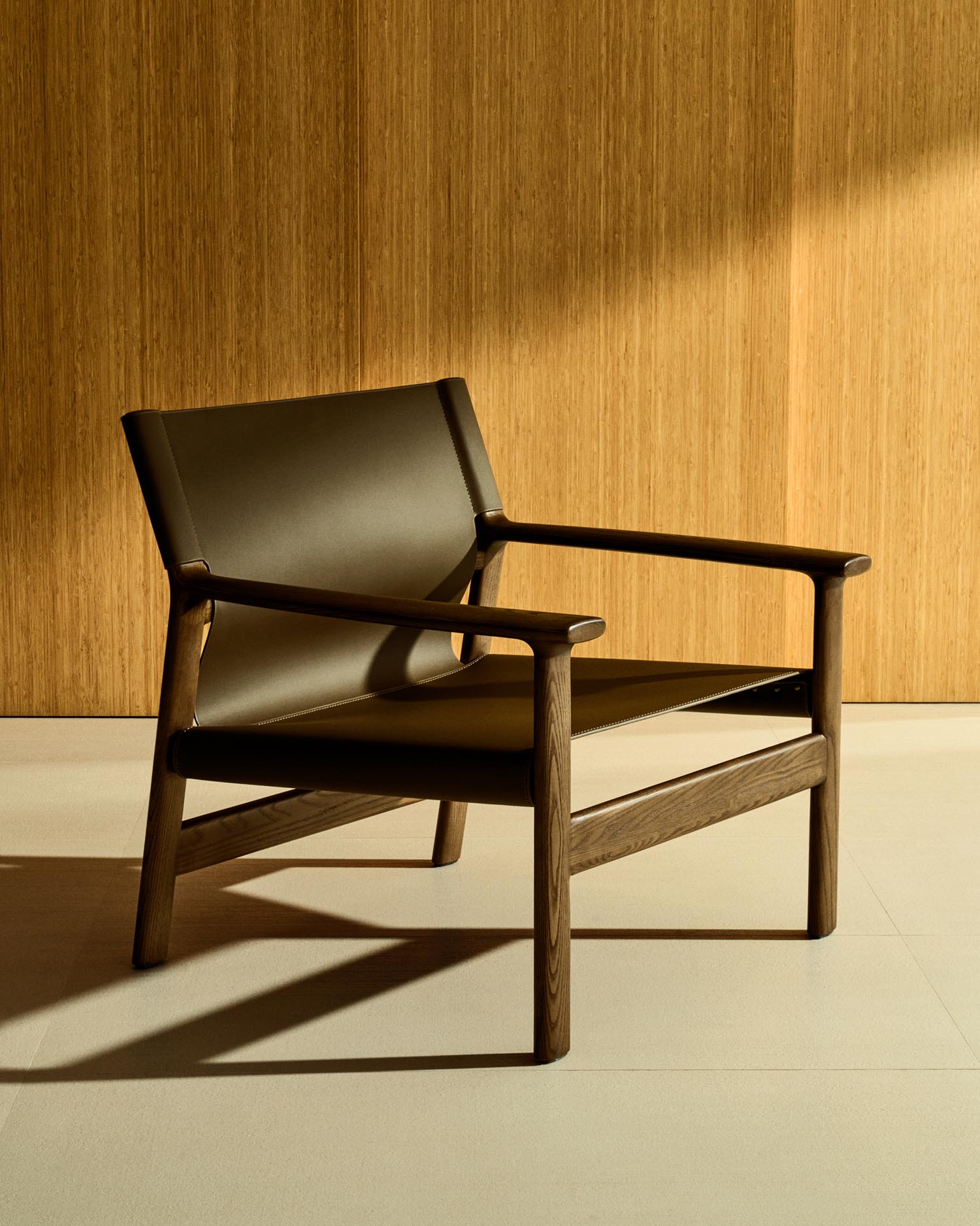 Entdecken Sie den stilvollen Sessel Jan von Kave Home: Dunkelbraunes, recyceltes Leder trifft auf FSC-zertifiziertes Eschenholz. Nachhaltig und elegant!