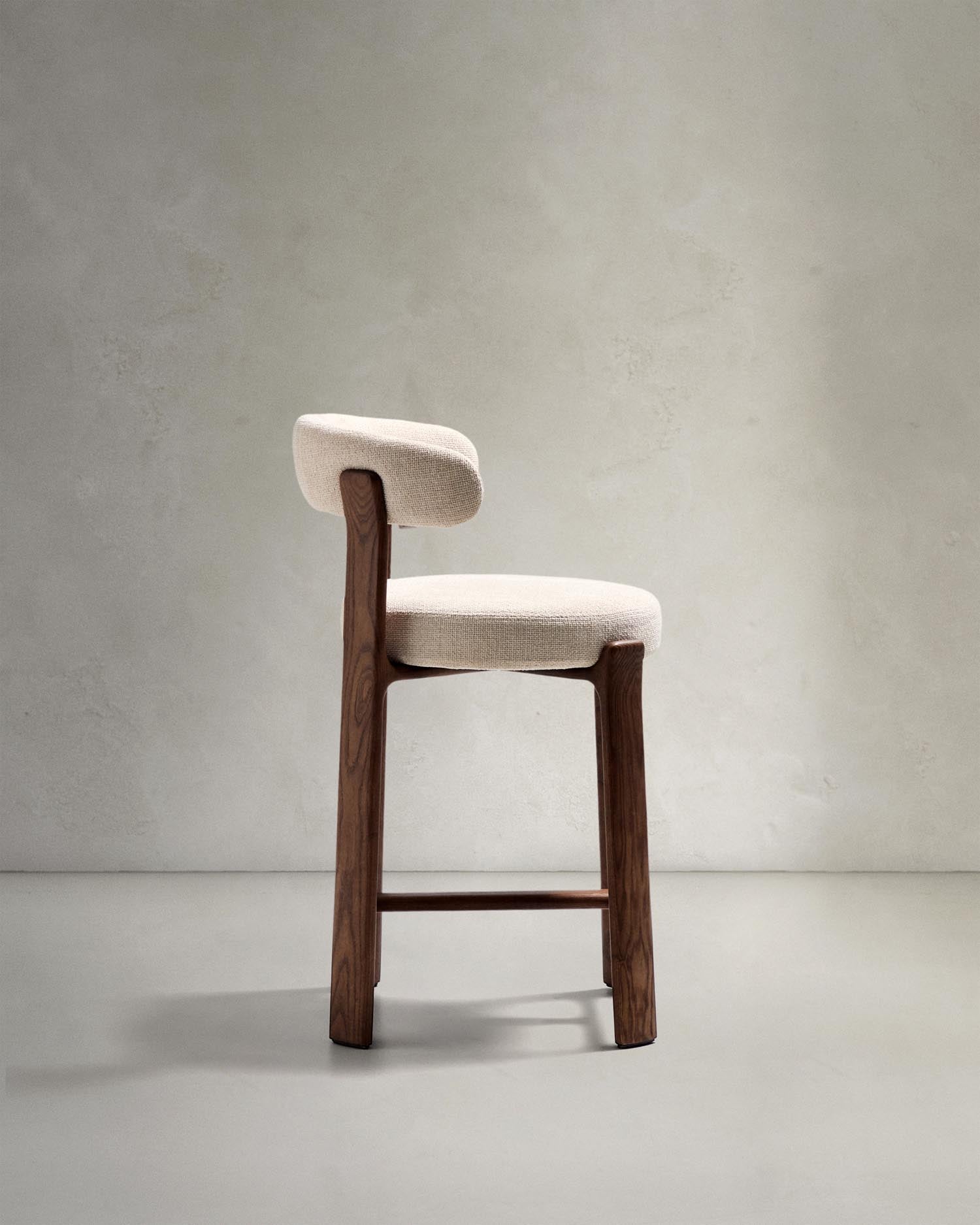 Entdecken Sie den Hocker Granite von Kave Home: Elegante Chenille und massives Eschenholz vereinen sich in einem stilvollen skandinavischen Design.