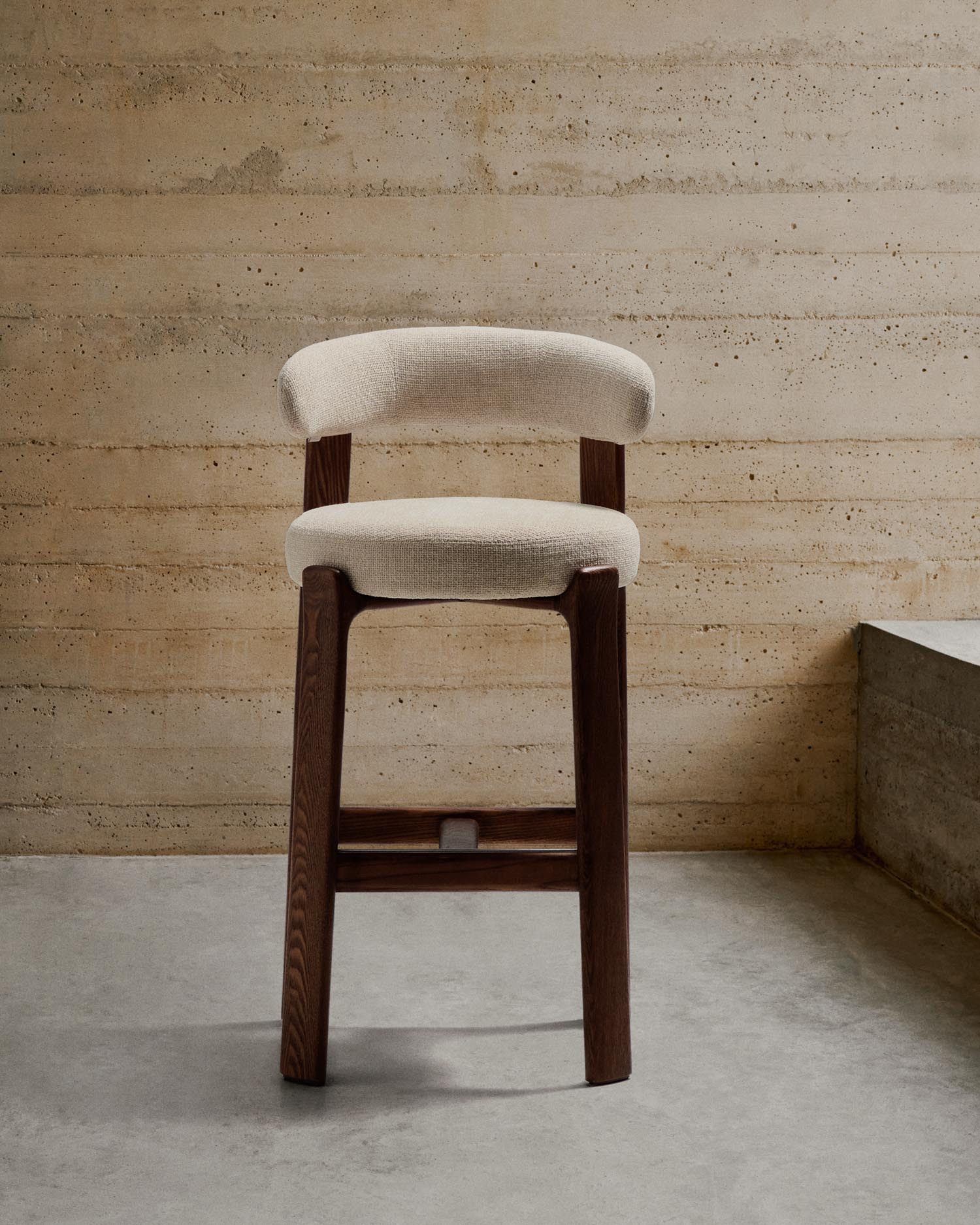 Entdecken Sie den Hocker Granite von Kave Home: Eleganz aus beigefarbener Chenille und FSC-zertifiziertem Eschenholz, ideal für jeden Raum.