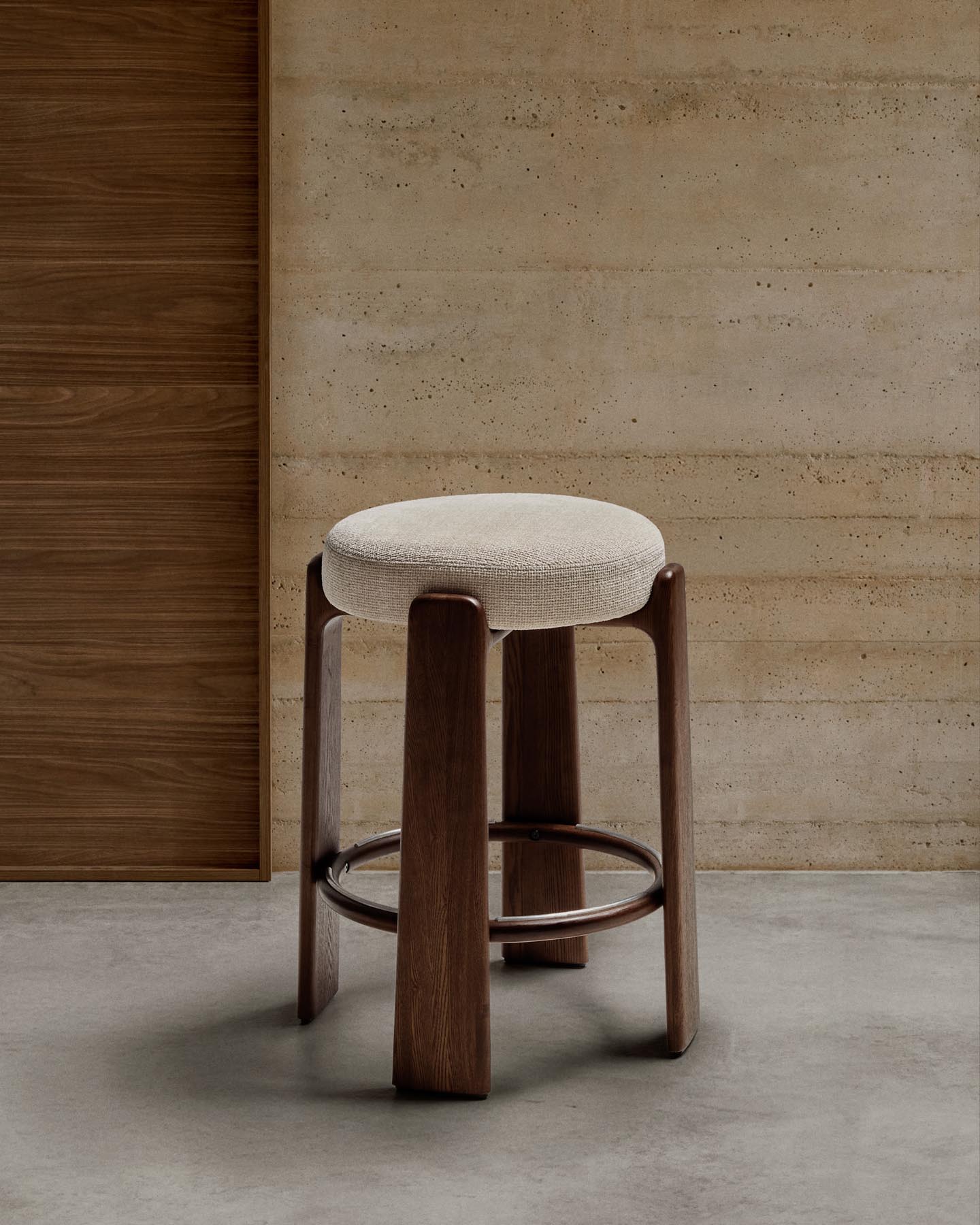 Eleganter Hocker Granite aus beiger Chenille und FSC-zertifiziertem Eschenholz mit nussbaumfarbenem Finish. Ideal für stilvolle Wohnräume.