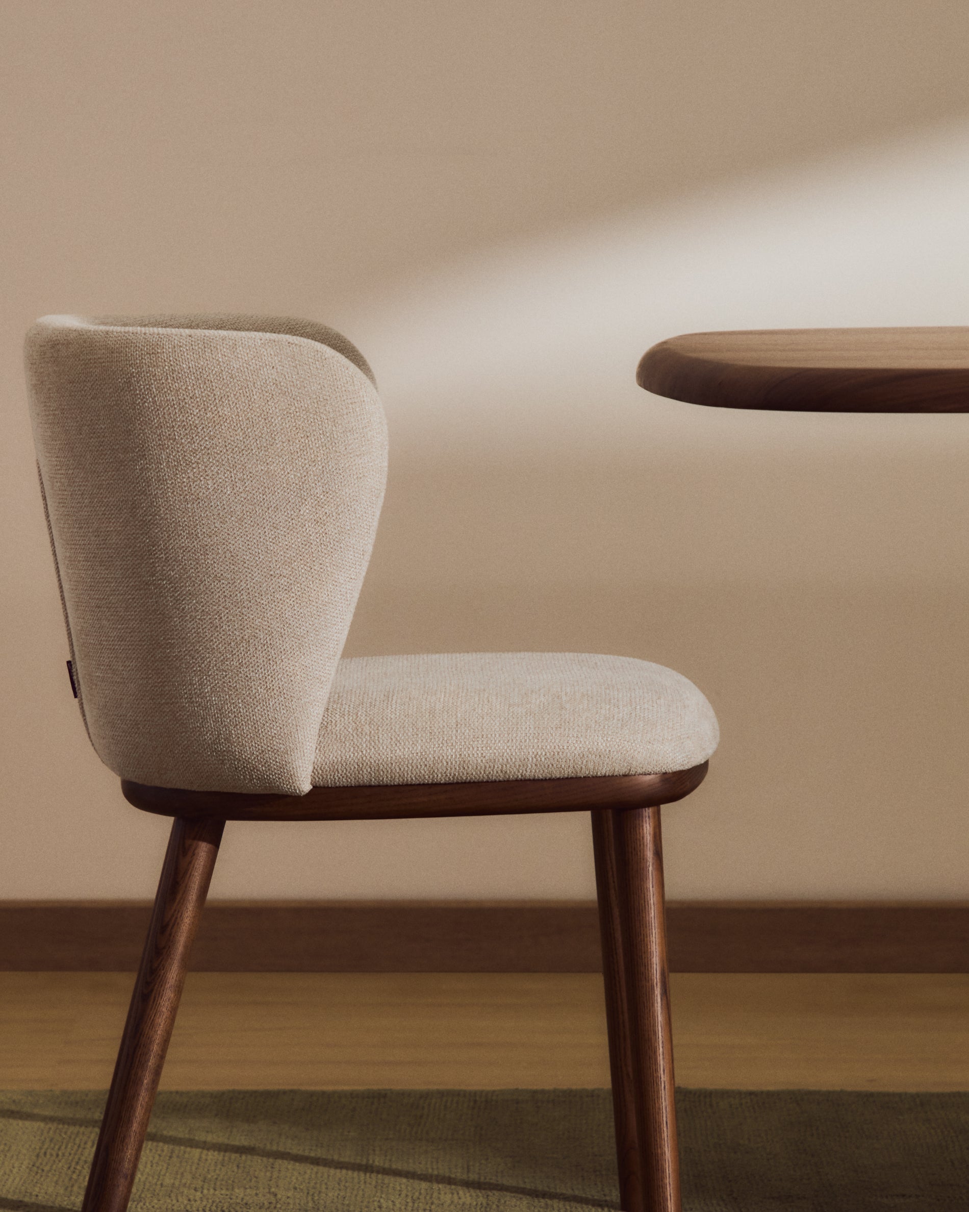 Beiger Chenille-Stuhl Ciselia mit robusten Eschenholzbeinen in edlem Walnussholz-Finish, perfekt für moderne Inneneinrichtungen.