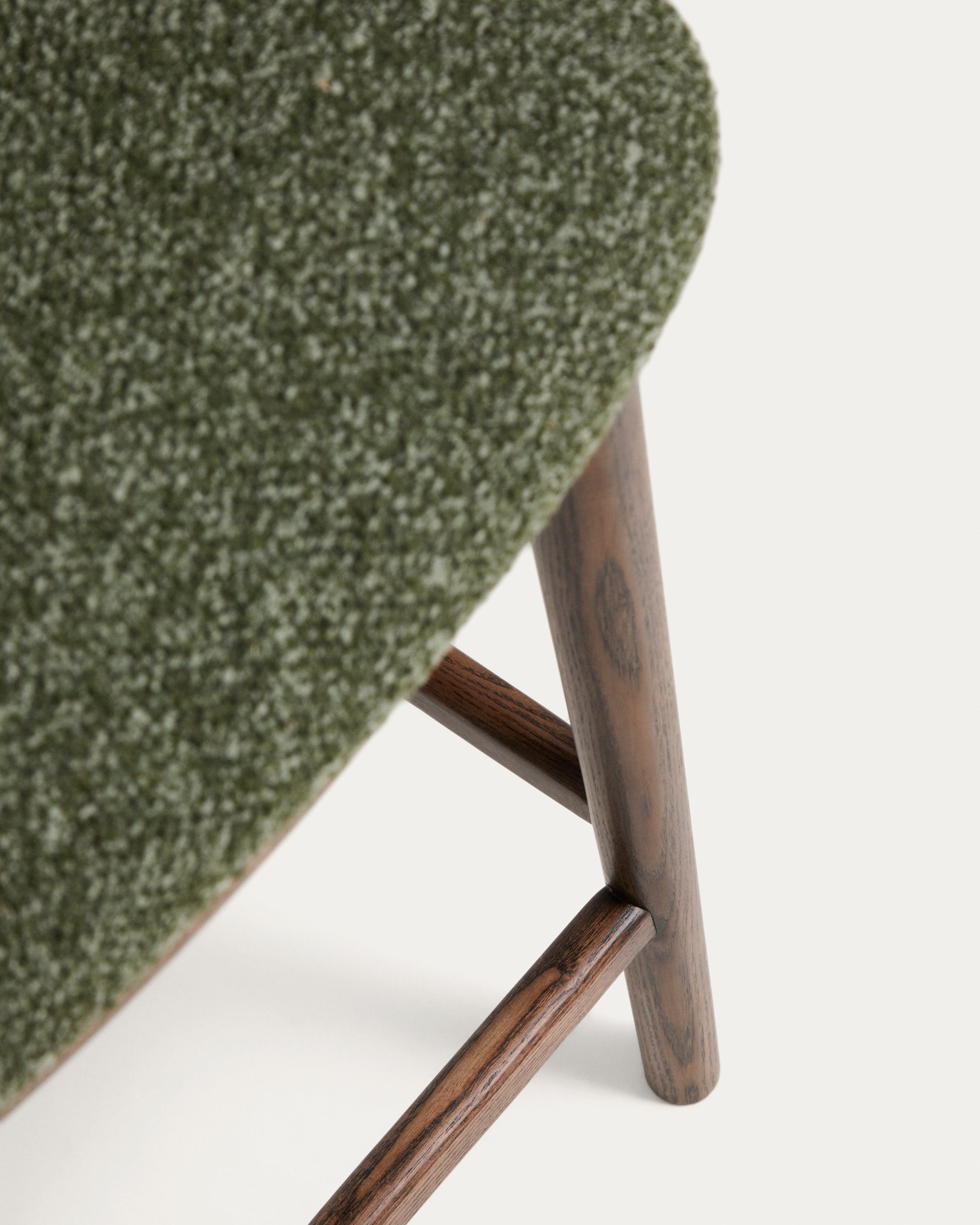 Eleganter Hocker Ciselia aus dickem, dunkelgrünem Chenille, ausgestattet mit stabilen Eschenholzbeinen in edler Walnussholzfarbe, perfekt für stilvolle Bars.