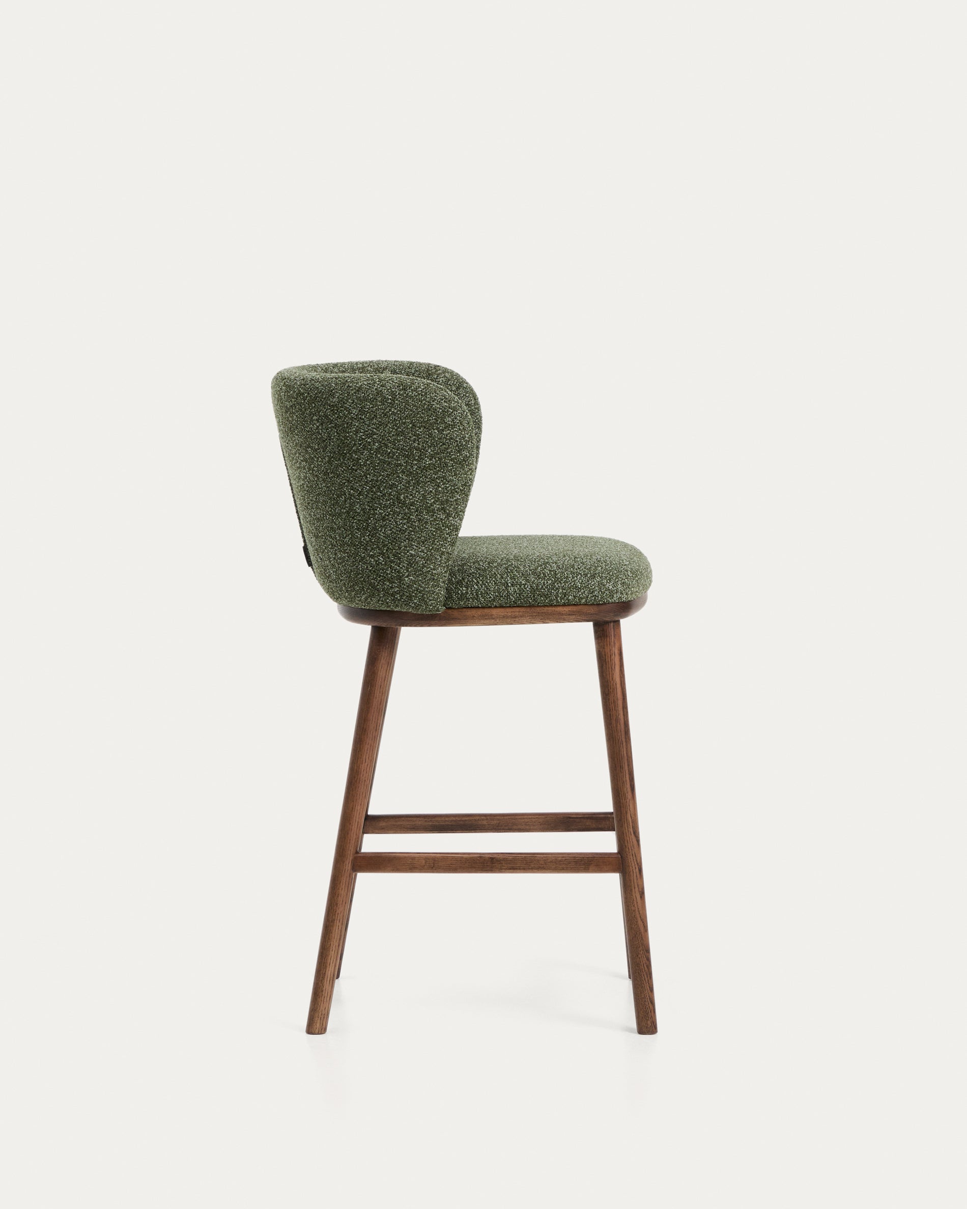 Eleganter Hocker Ciselia aus dickem, dunkelgrünem Chenille, ausgestattet mit stabilen Eschenholzbeinen in edlem Walnussholz-Finish.