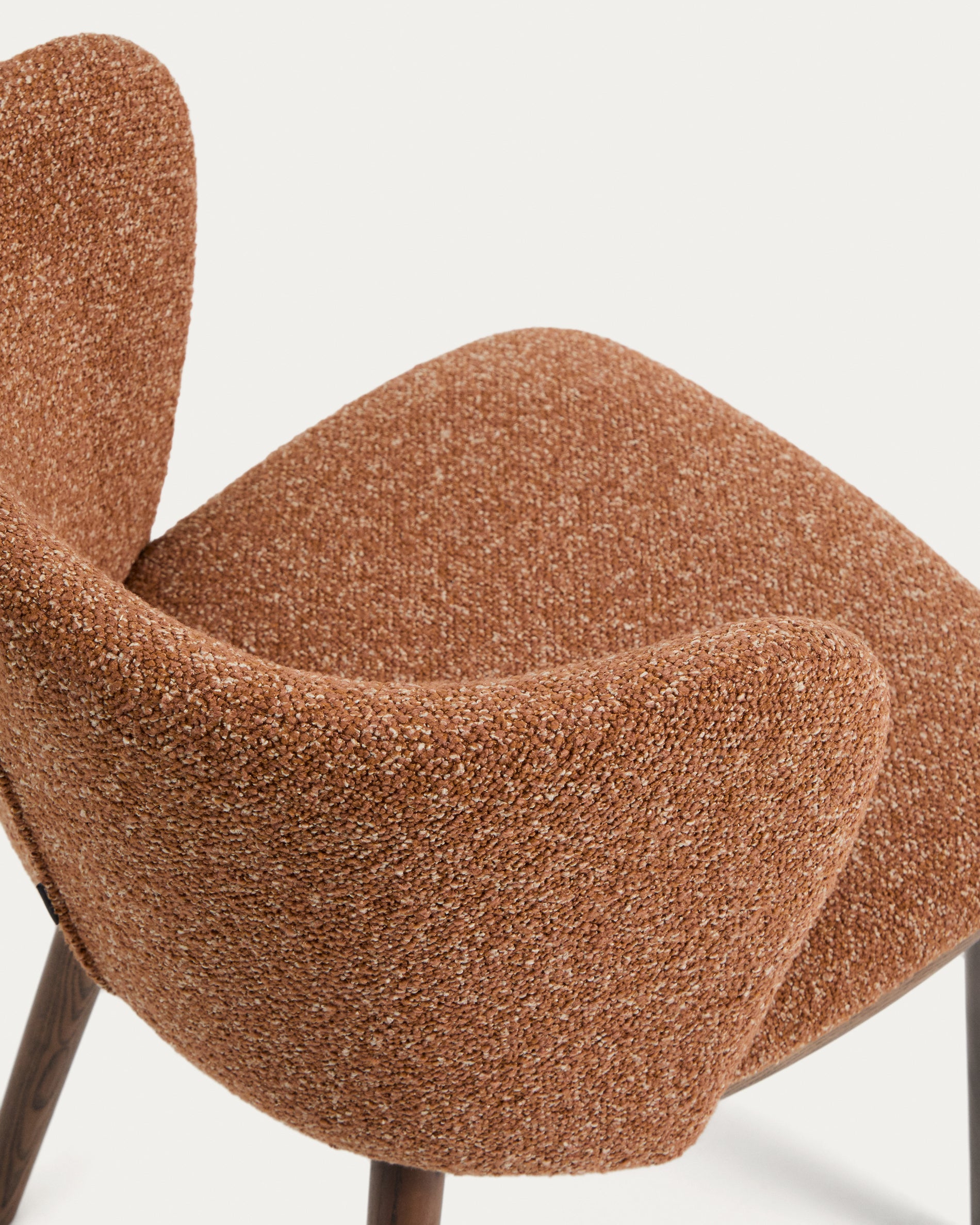 Stylischer Hocker Ciselia aus dickem, terrakottafarbenem Chenille, mit robusten Eschenholzbeinen in edler Walnussfarbe, perfekt für moderne Wohnräume.