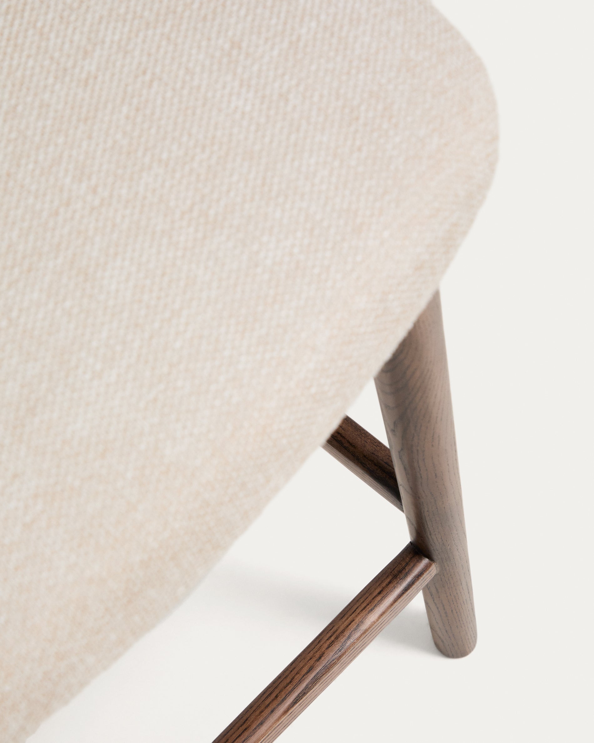 Beiger Chenille-Hocker Ciselia mit robusten Eschenholzbeinen in Walnussholz-Optik, perfekt für moderne Bar- und Wohnräume.