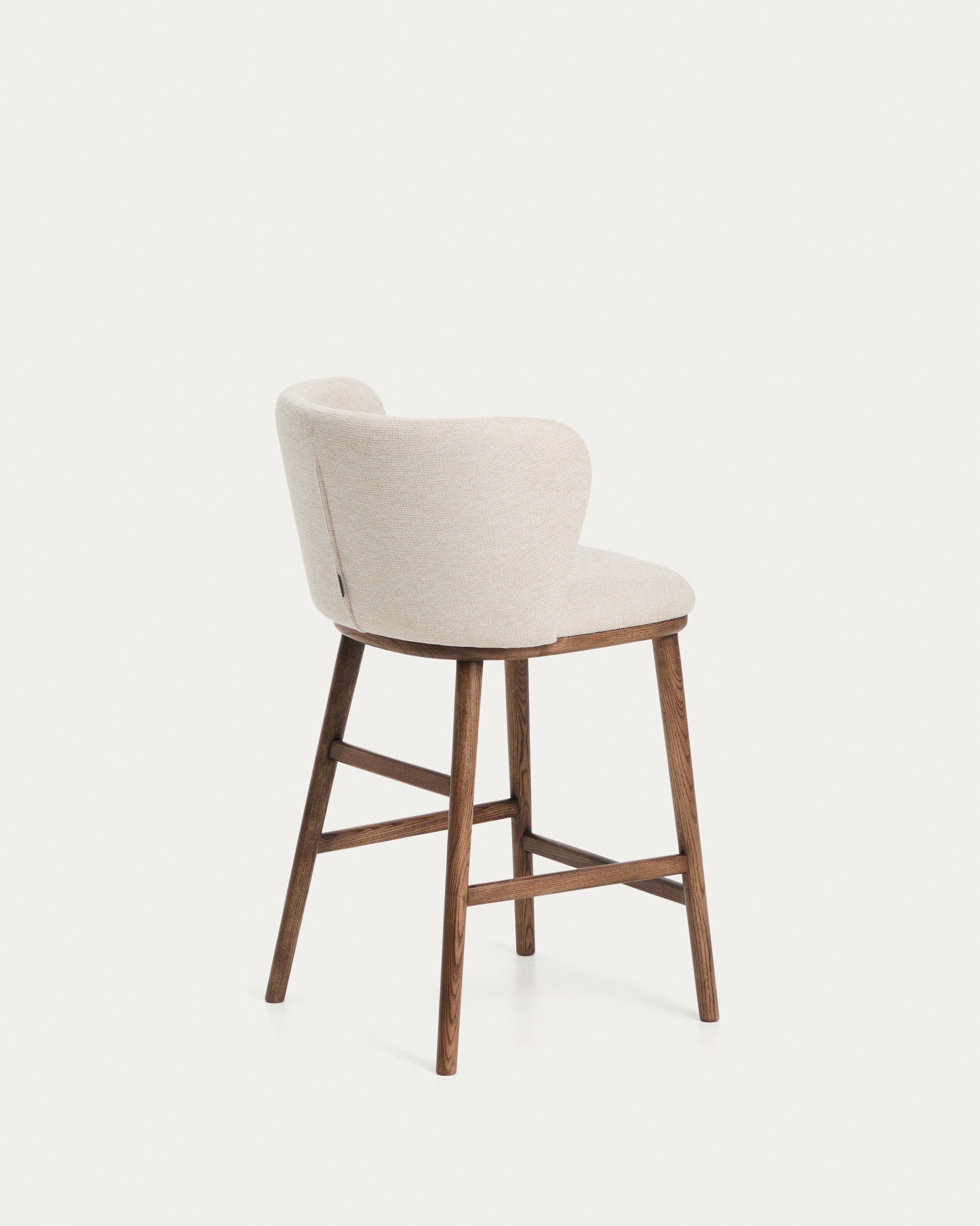 Beiger Chenille-Hocker Ciselia mit robusten Eschenholzbeinen in Walnussholz-Optik, perfekt für moderne Bar- und Wohnräume.