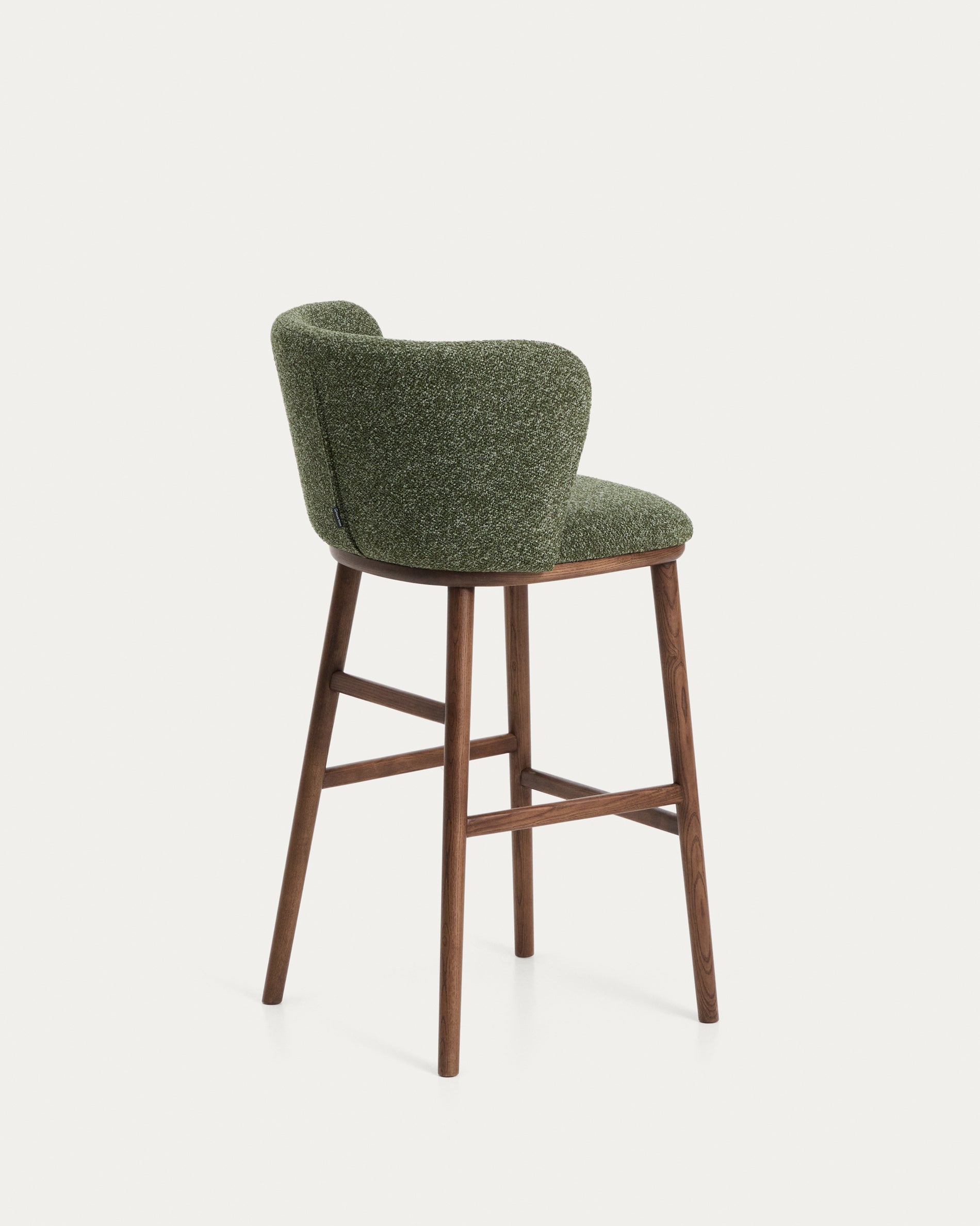 Moderner Hocker Ciselia in dunklem Chenille, mit robusten Eschenholzbeinen in edler Walnussholzfarbe, perfekt für Bar- und Essbereiche.