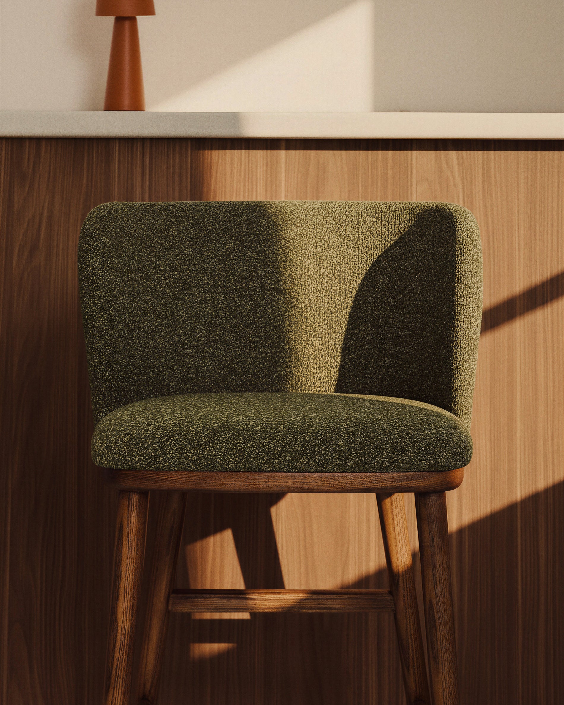 Stilvoller Hocker Ciselia in dunklem Grün aus weicher Chenille, mit robusten Eschenholzbeinen in edler Walnussholzfarbe, perfekt für moderne Einrichtungen.