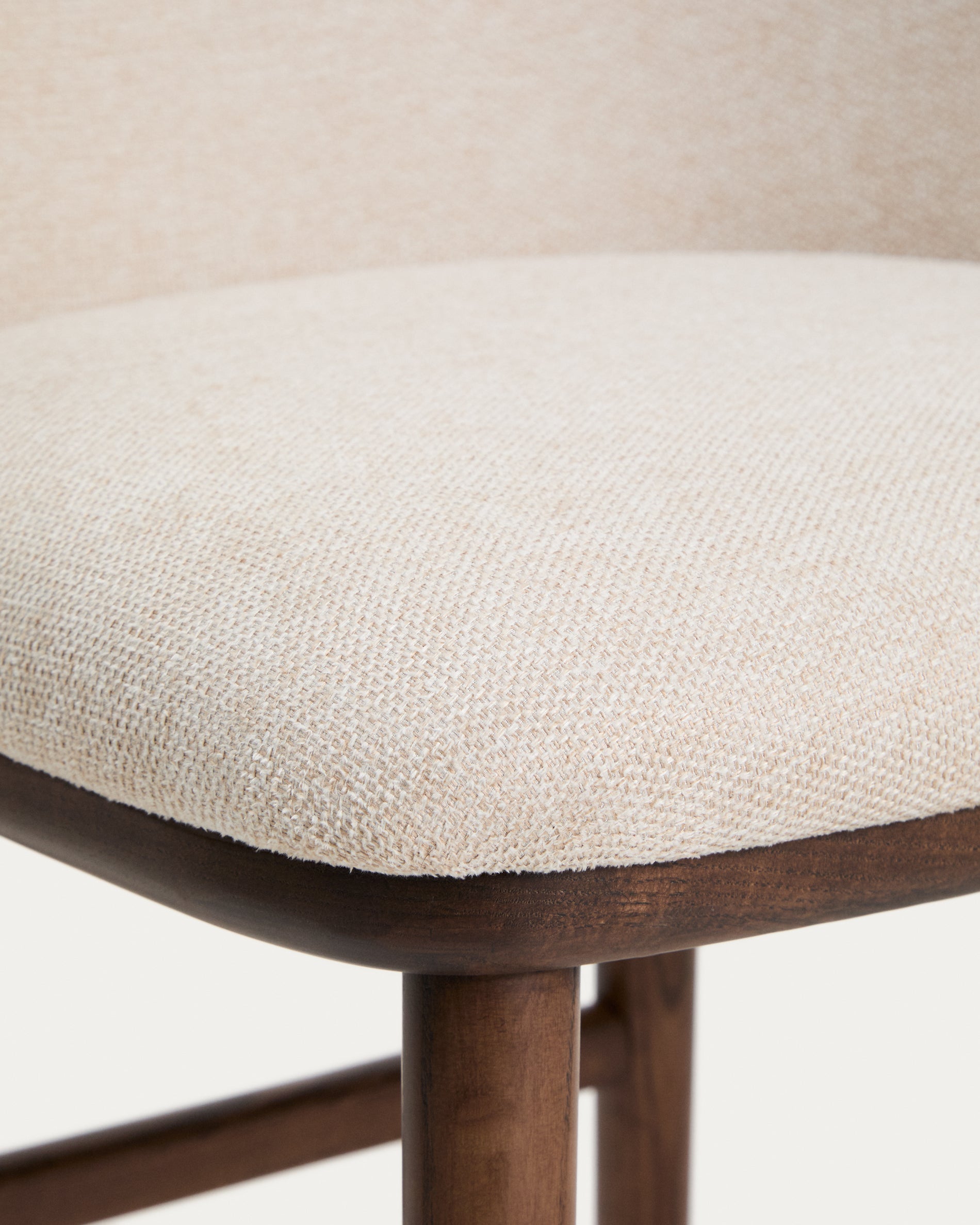 Eleganter Hocker Ciselia in beigem Chenille, ausgestattet mit stabilen Eschenholzbeinen in Walnussholzoptik, ideal für stilvolle Bar- und Wohnräume.