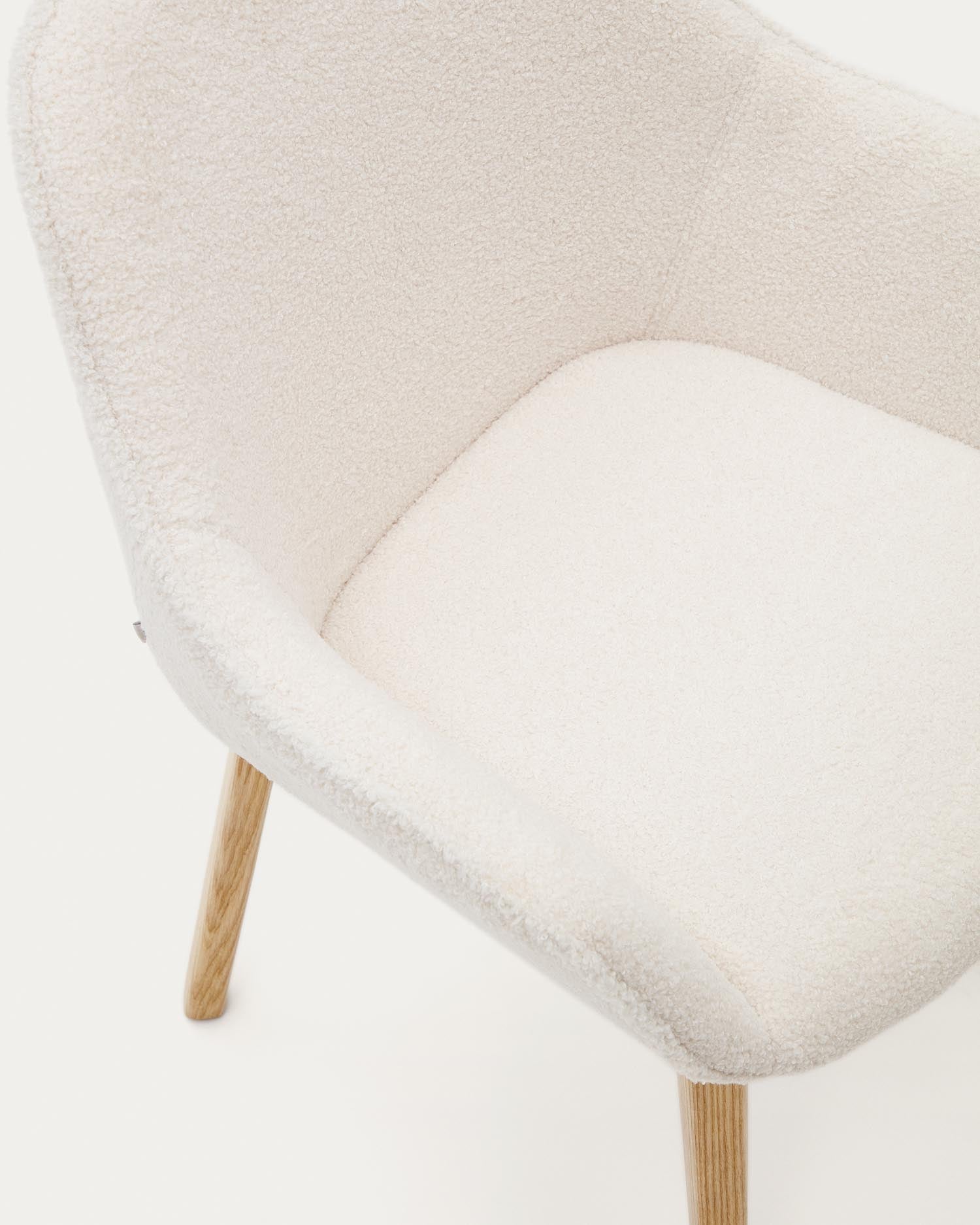 Moderner Aleli Stuhl mit weißem Bouclé-Stoff und stabilen Beinen aus massivem Eschenholz mit natürlichem Finish von Kave Home.