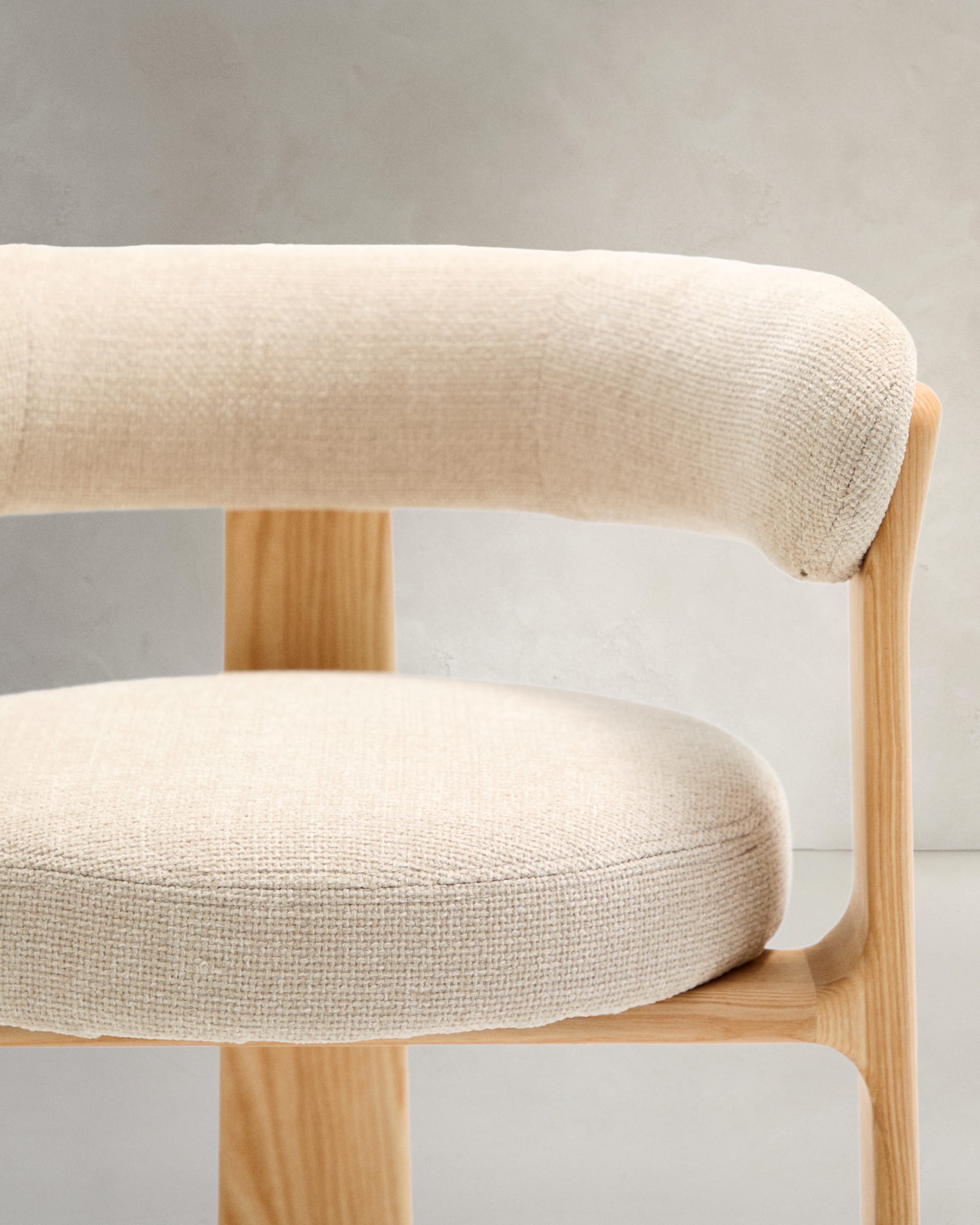 Eleganter 3-beiniger Stuhl mit beiger Chenille-Polsterung, aus massivem Eschenholz mit natürlichem Finish, FSC-zertifiziert, von Kave Home.
